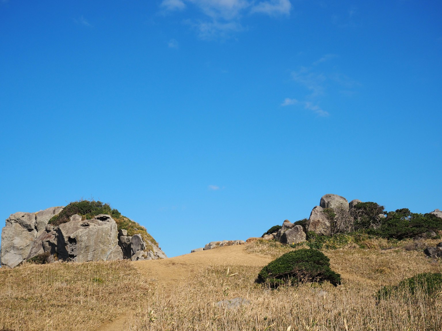 Paesaggio di prateria e rocce sotto un cielo blu