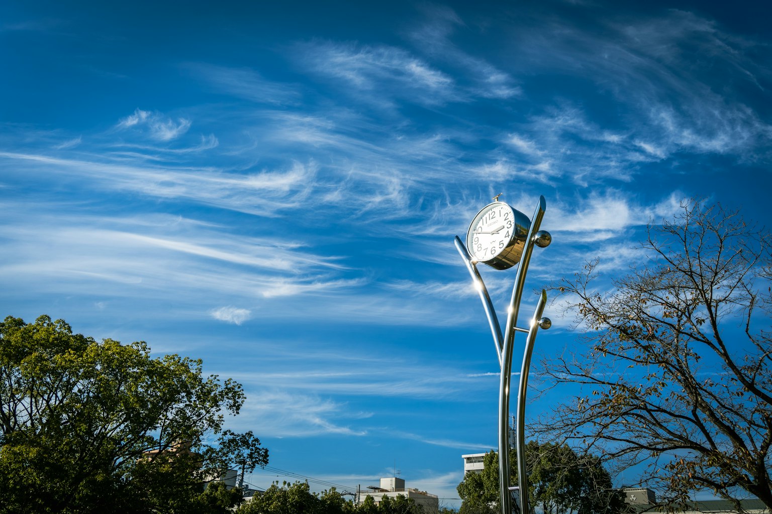 Artistic sculpture under a blue sky with clouds