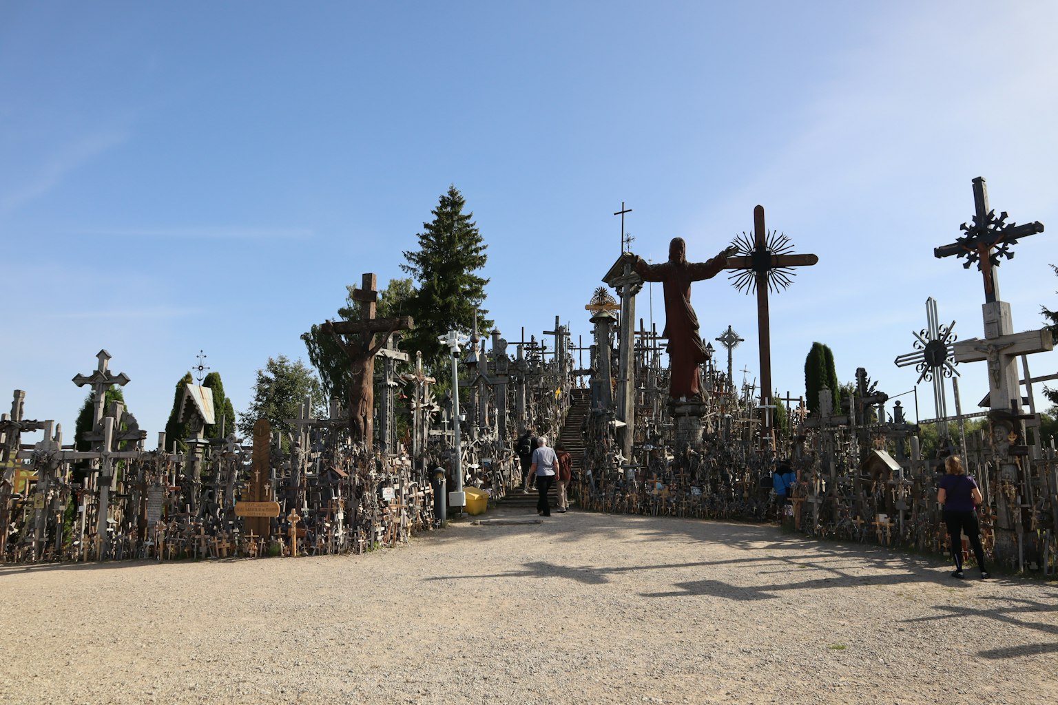 Paisaje de una colina cubierta de cruces con visitantes