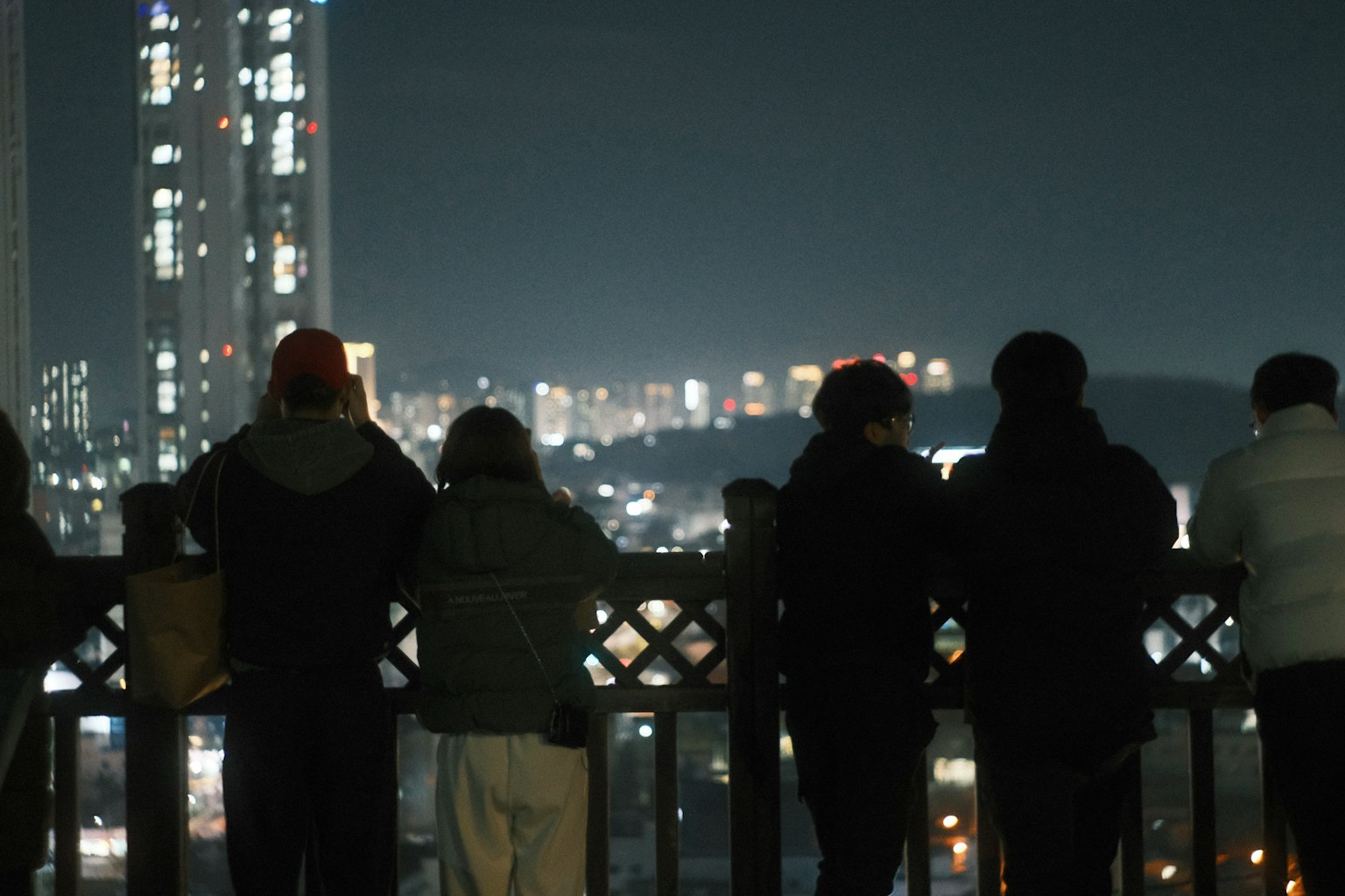 Silhouette di persone che osservano lo skyline di una città di notte