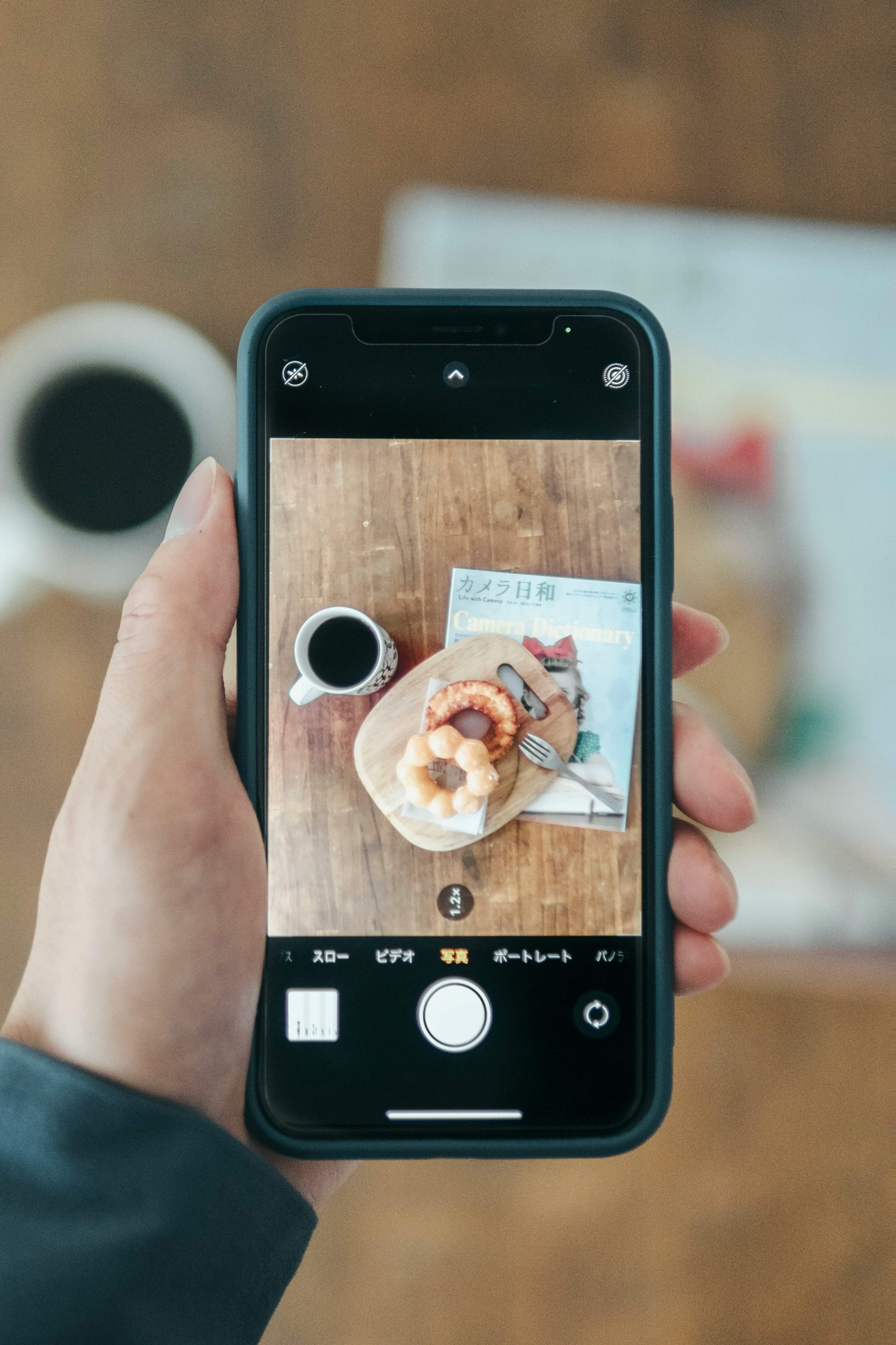 hand holding a smartphone showing a cafe food photo on screen