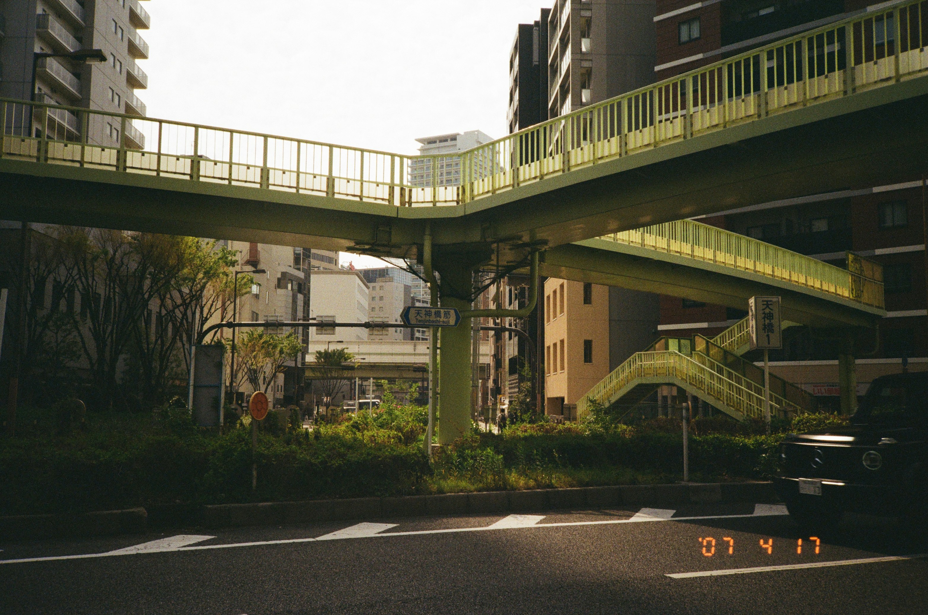 高架の歩道と高層ビルが交差する都市の通りの風景