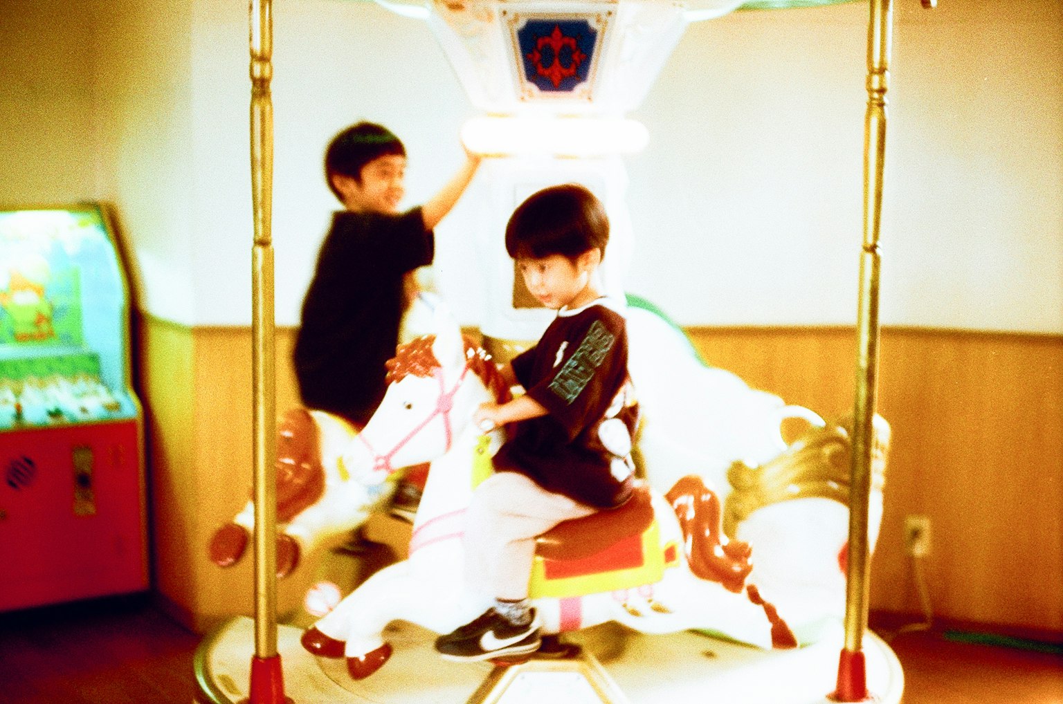 子供たちがメリーゴーラウンドに乗っている遊園地のシーン