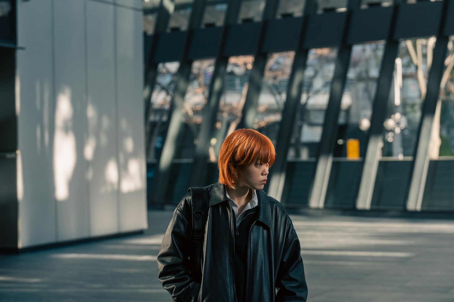 A boy with red hair standing inside a modern building