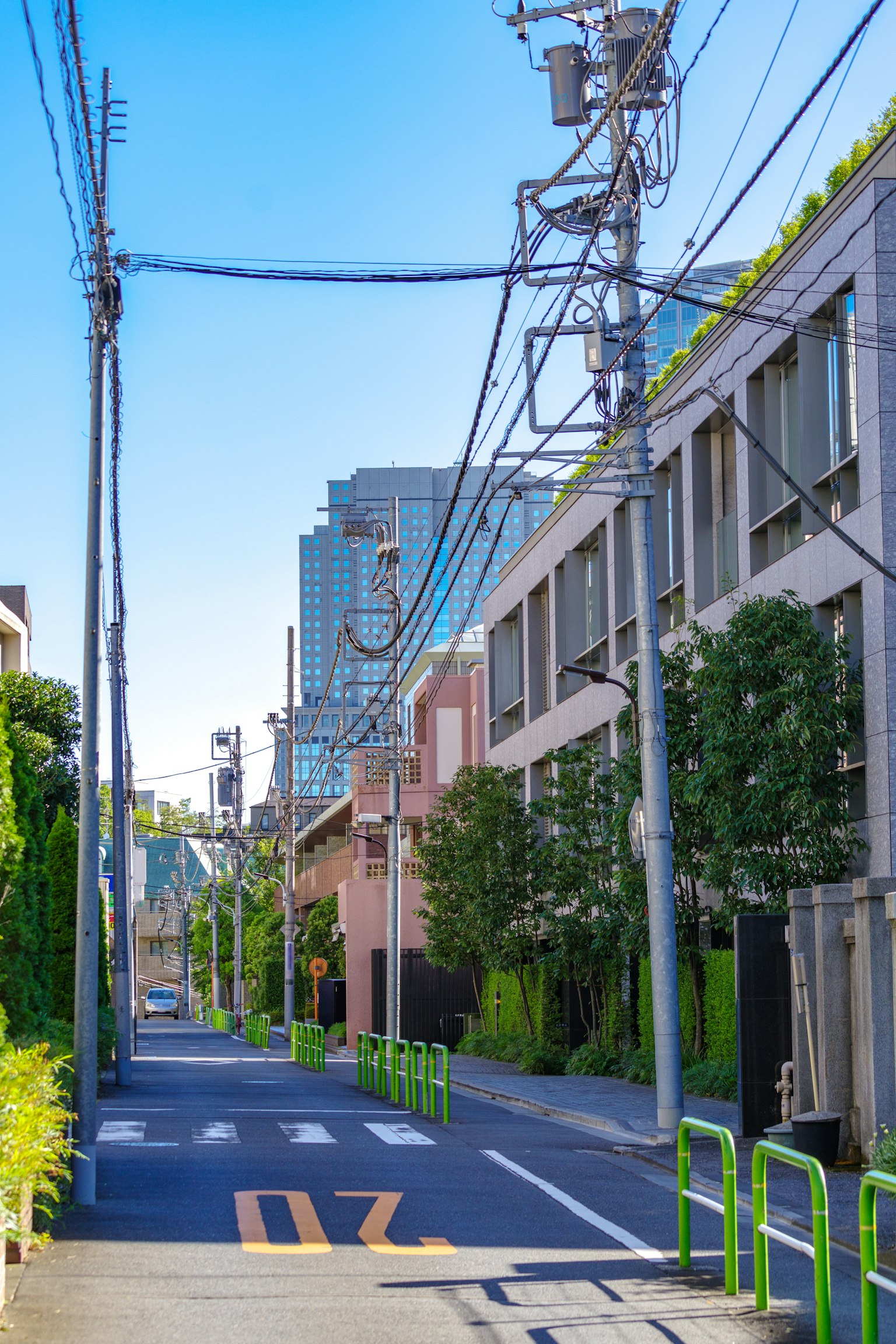 Strada tranquilla sotto un cielo blu con edifici moderni e linee elettriche