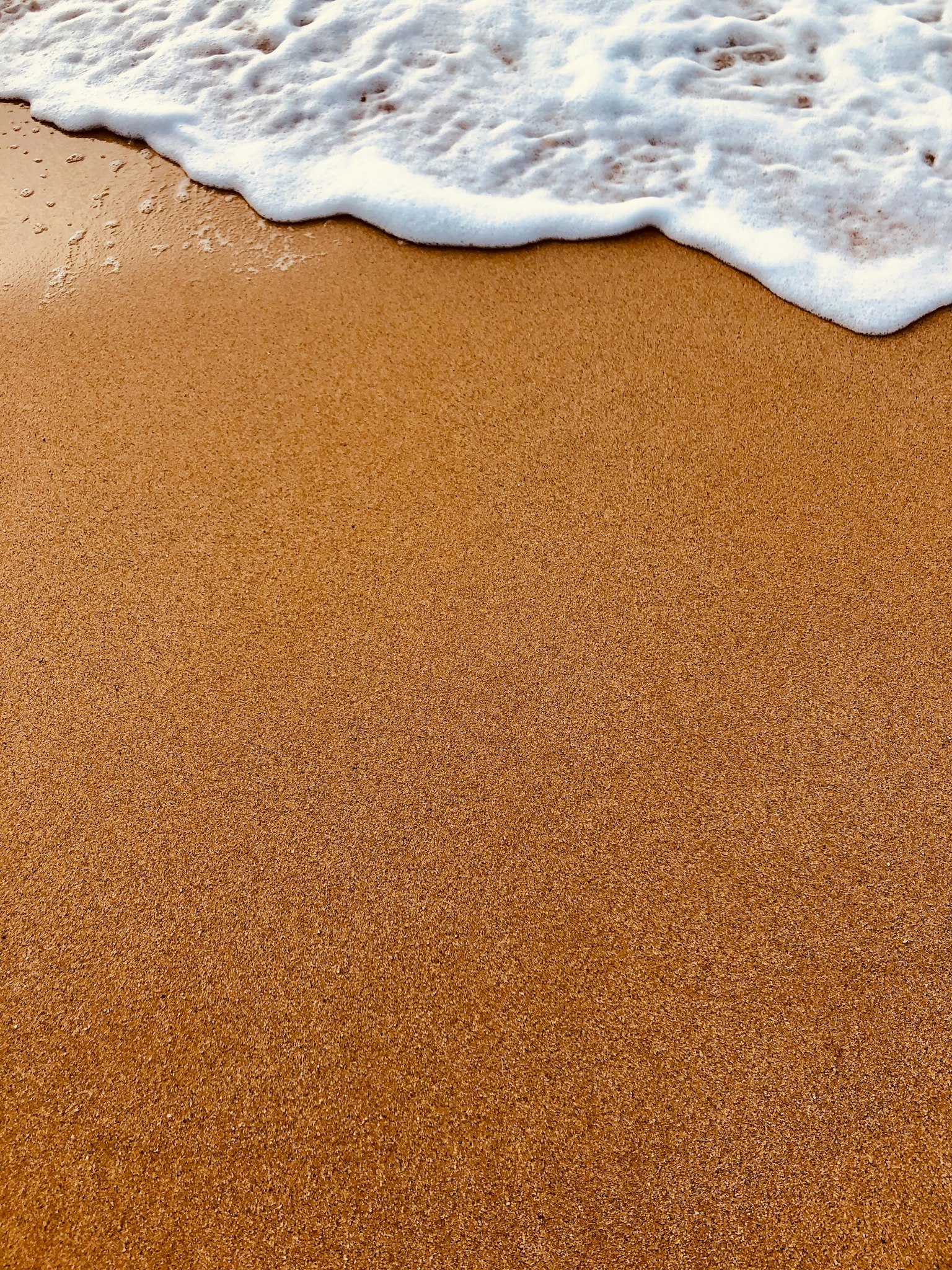 Gros plan sur une plage de sable avec des vagues douces