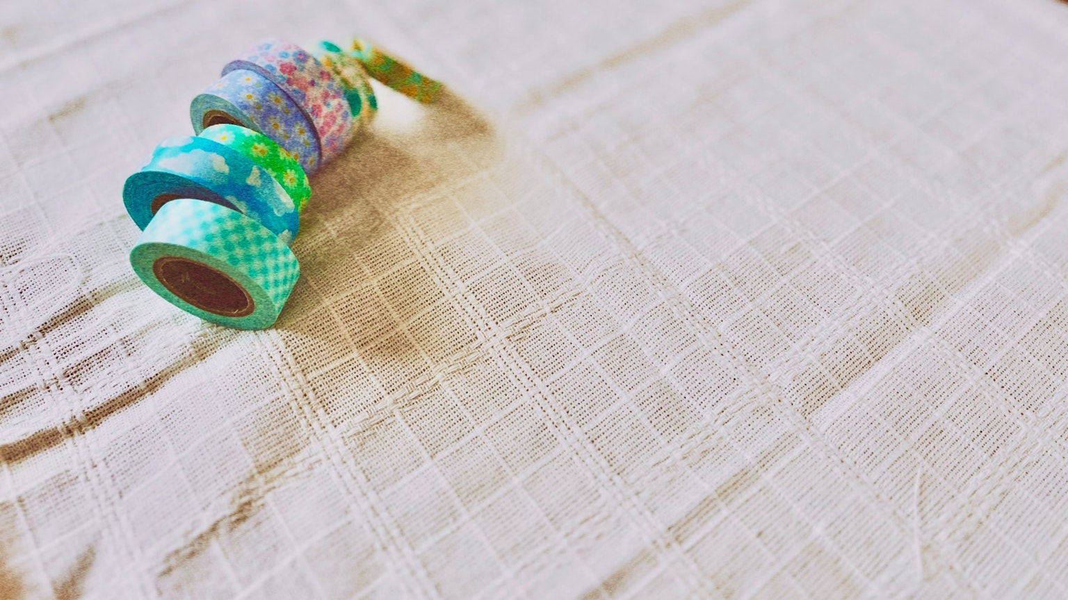 Colorful washi tapes arranged on a textured fabric surface