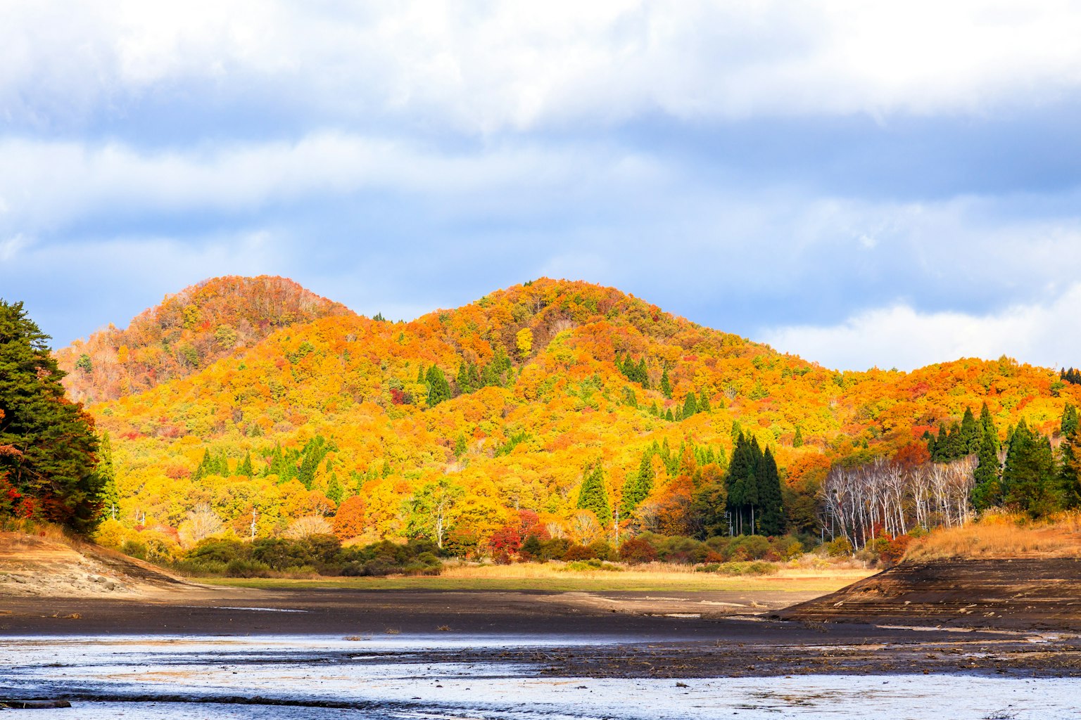 Vue panoramique de montagnes aux couleurs d'automne sous un ciel bleu