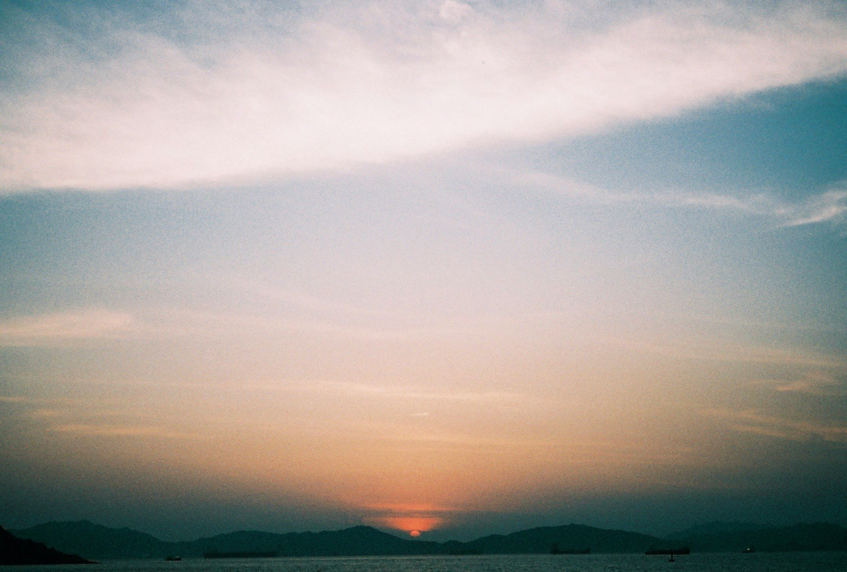 水平線に沈む夕日と雲の空