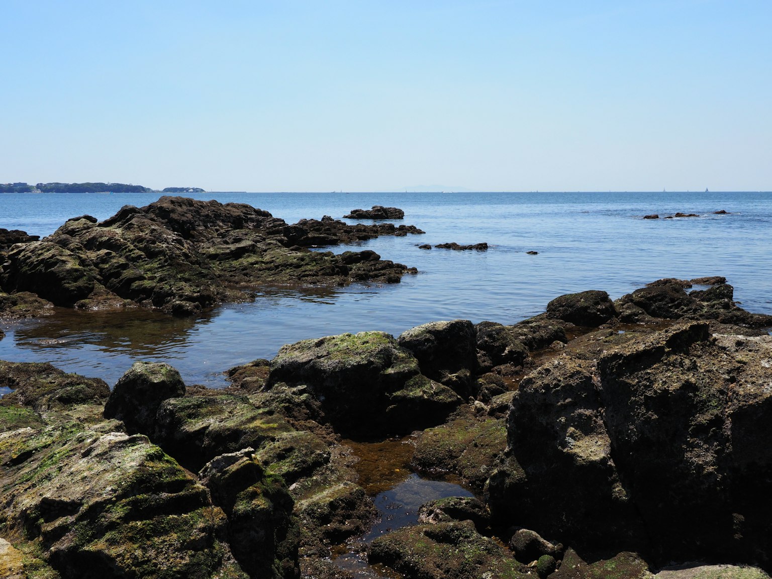 Pemandangan pantai dengan formasi batu dan air tenang