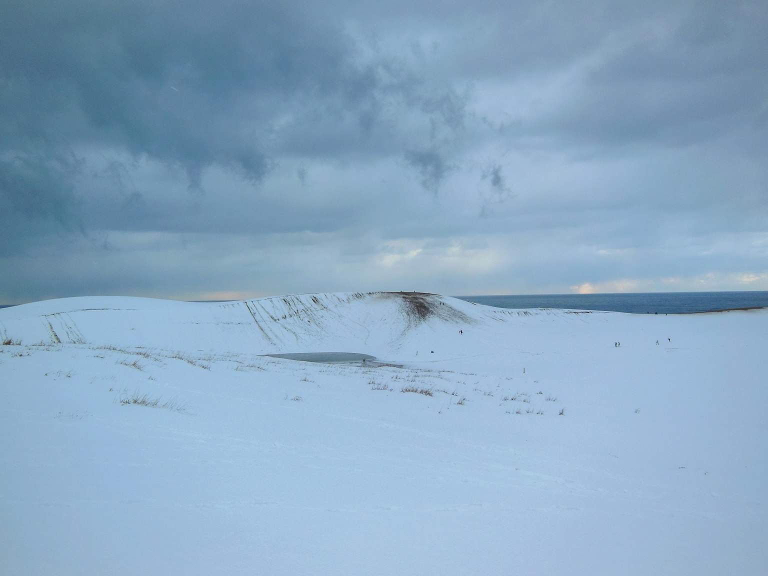 Amplio paisaje nevado con nubes oscuras encima