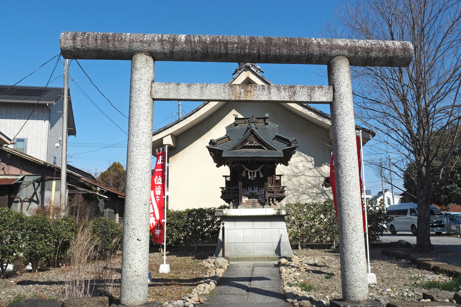 Puerta torii frente a un santuario con cielo azul claro