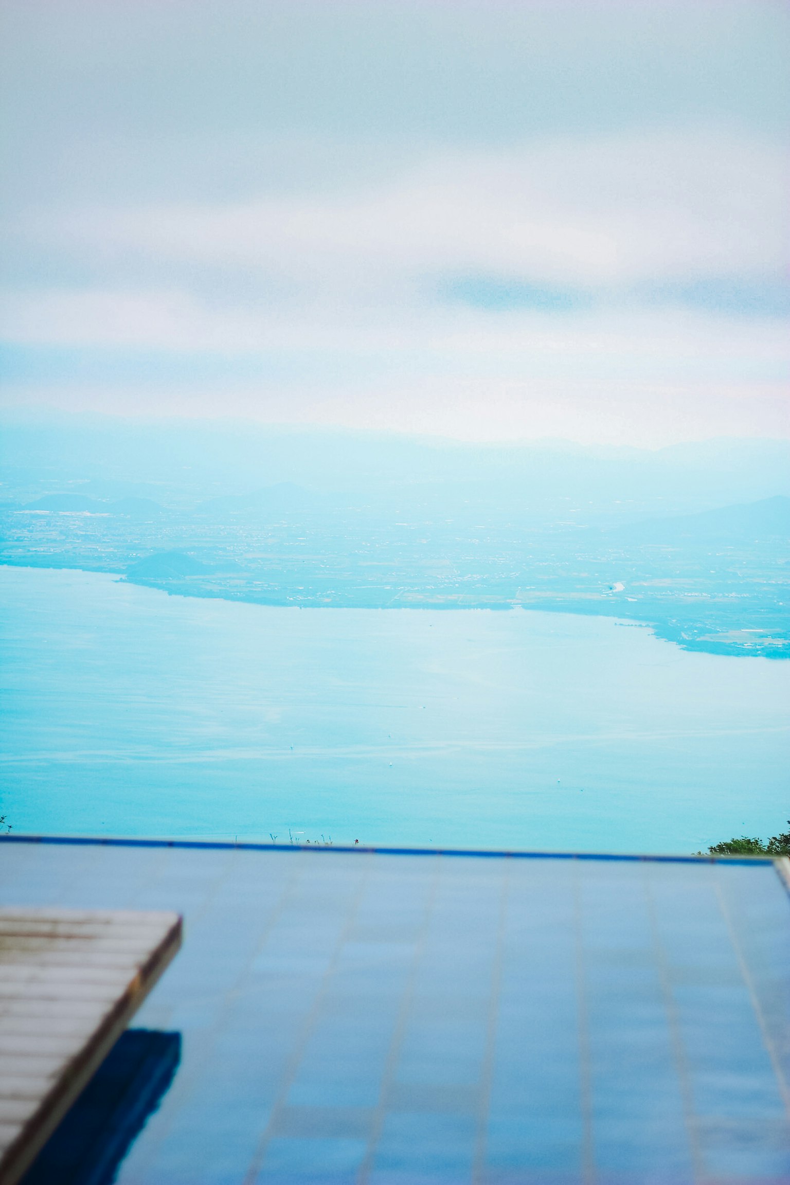 Malerscher Blick auf einen Pool mit Blick auf eine ruhige blaue Wasseroberfläche und den Himmel