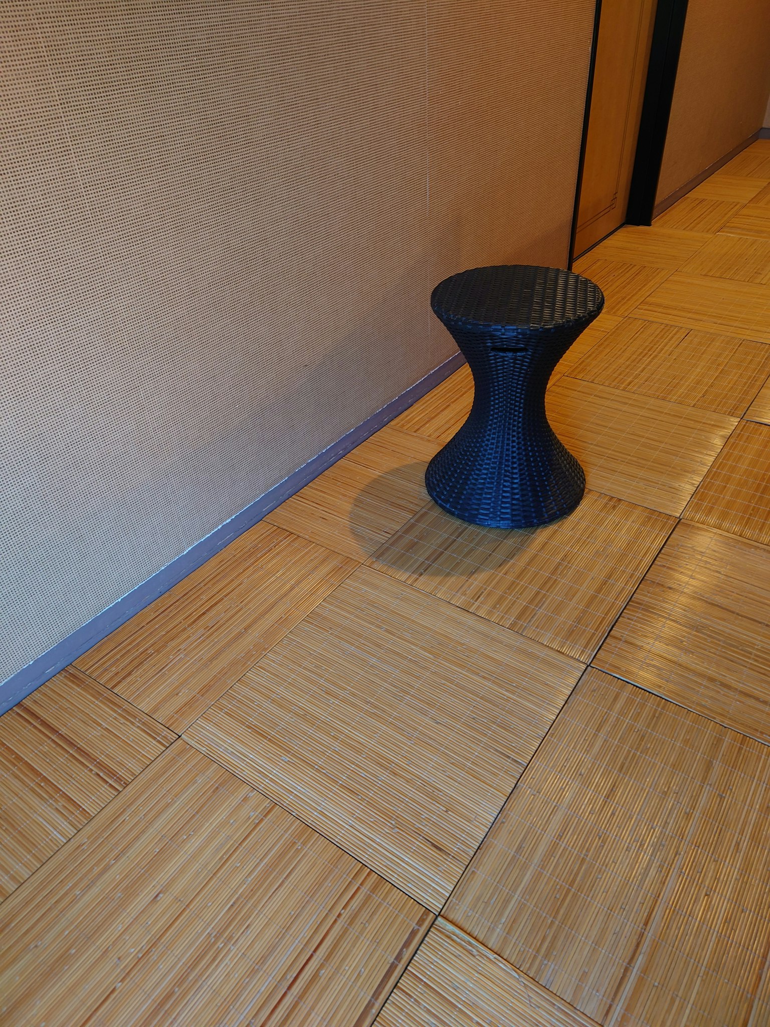 Interior corner featuring a black stool and wooden flooring