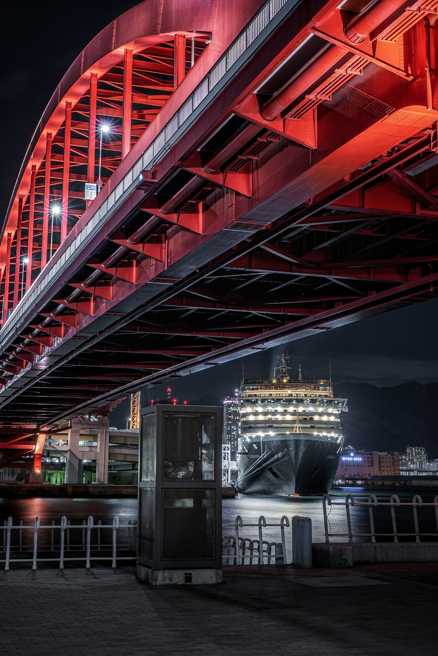 เรือจอดอยู่ใต้สะพานสีแดงพร้อมทัศนียภาพยามค่ำคืน