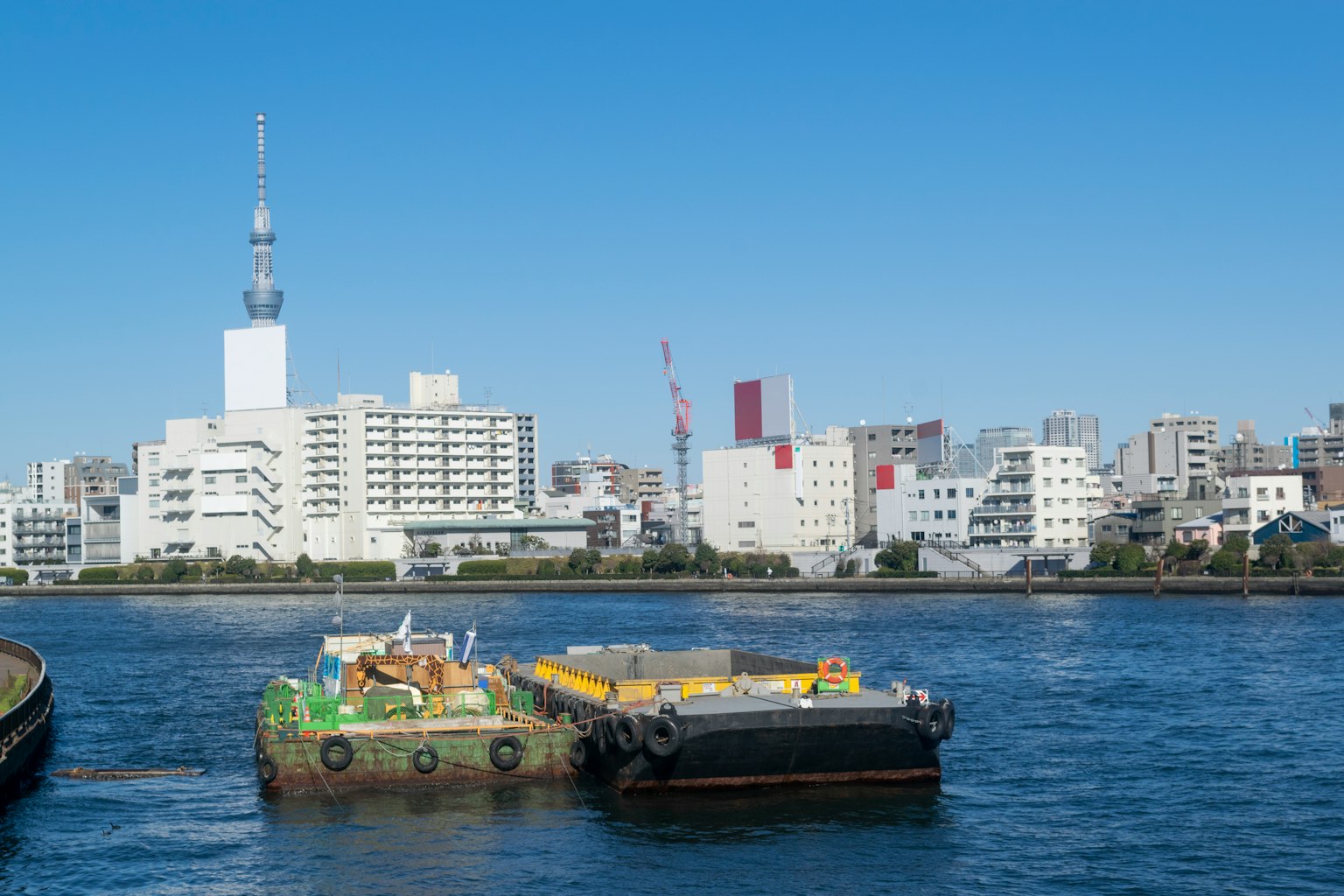 Barge flotando en un río con horizonte urbano