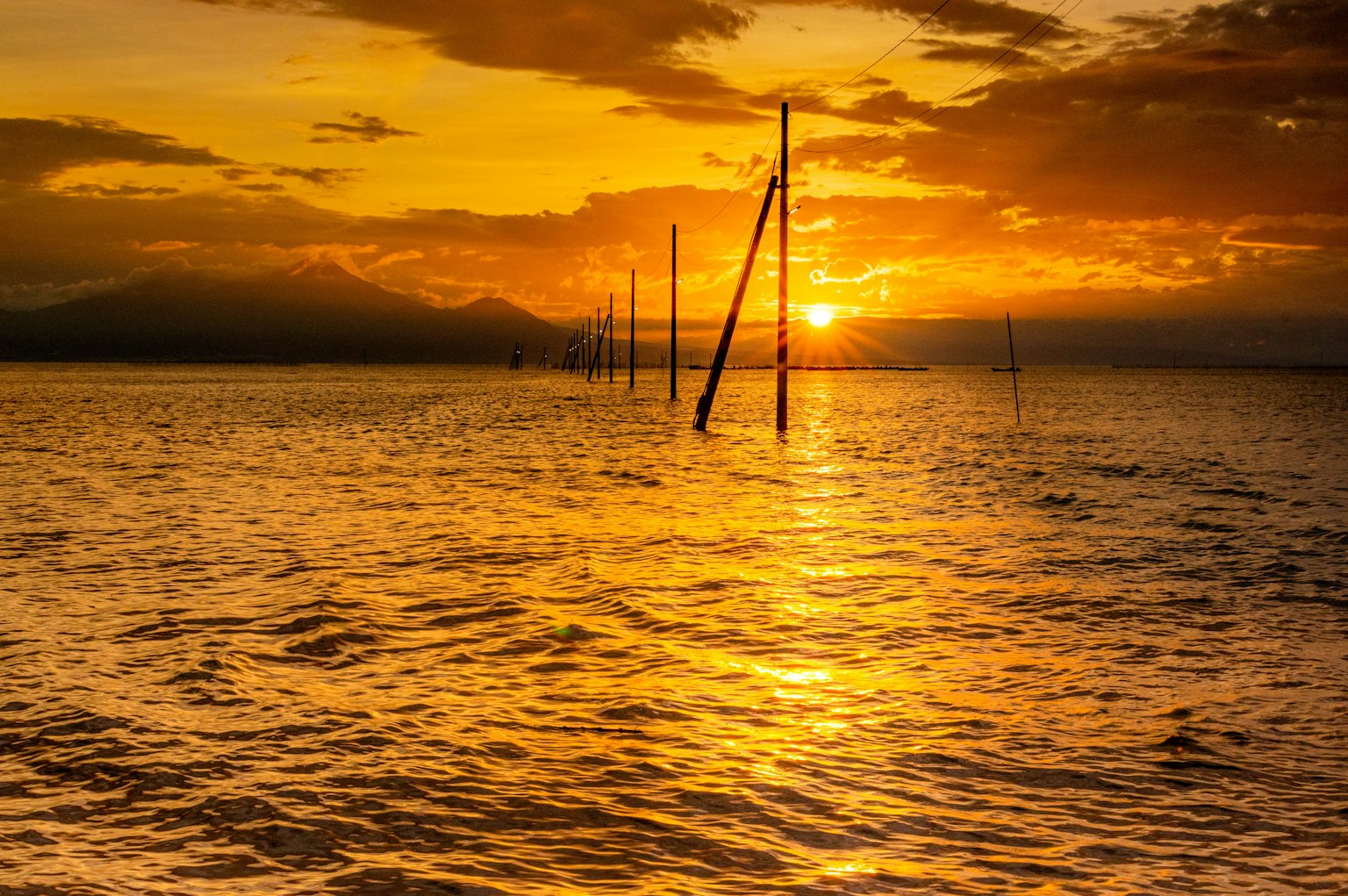 Ein wunderschöner Sonnenuntergang, der sich auf dem Meer spiegelt, mit verschiedenen Orangetönen im Himmel und schimmerndem Wasser