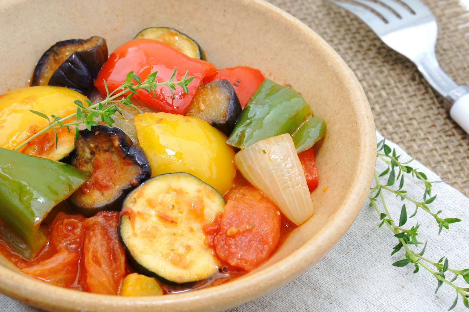 Ciotola di ratatouille colorata con zucchine, peperoni e pomodori