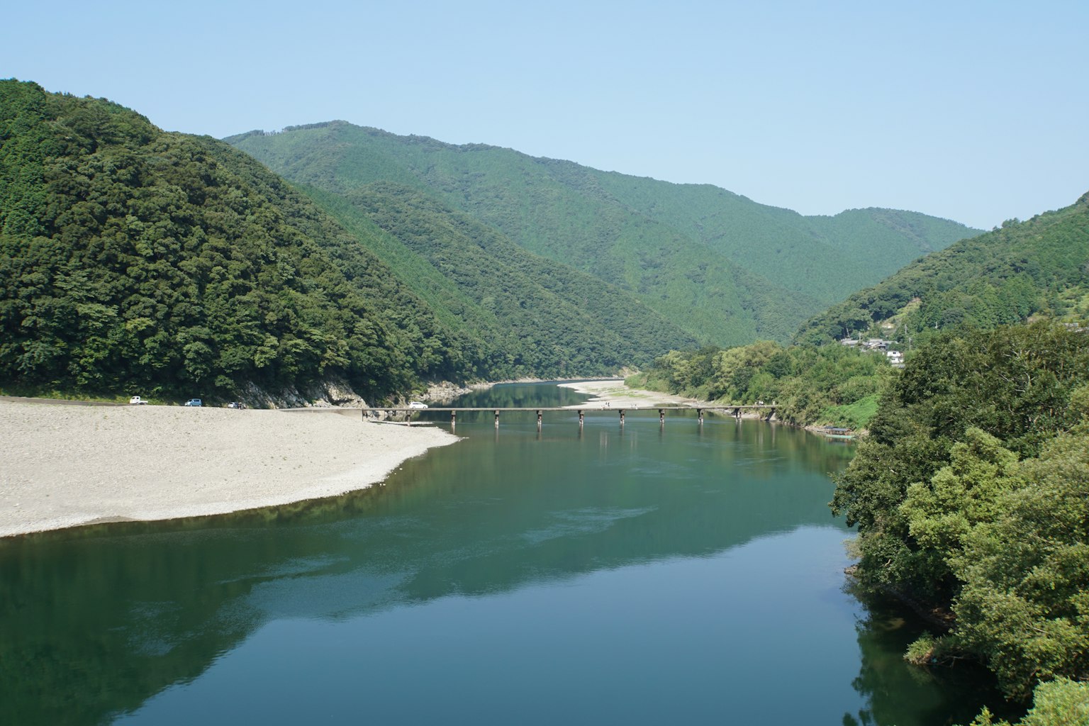 Paesaggio fluviale sereno circondato da montagne verdeggianti