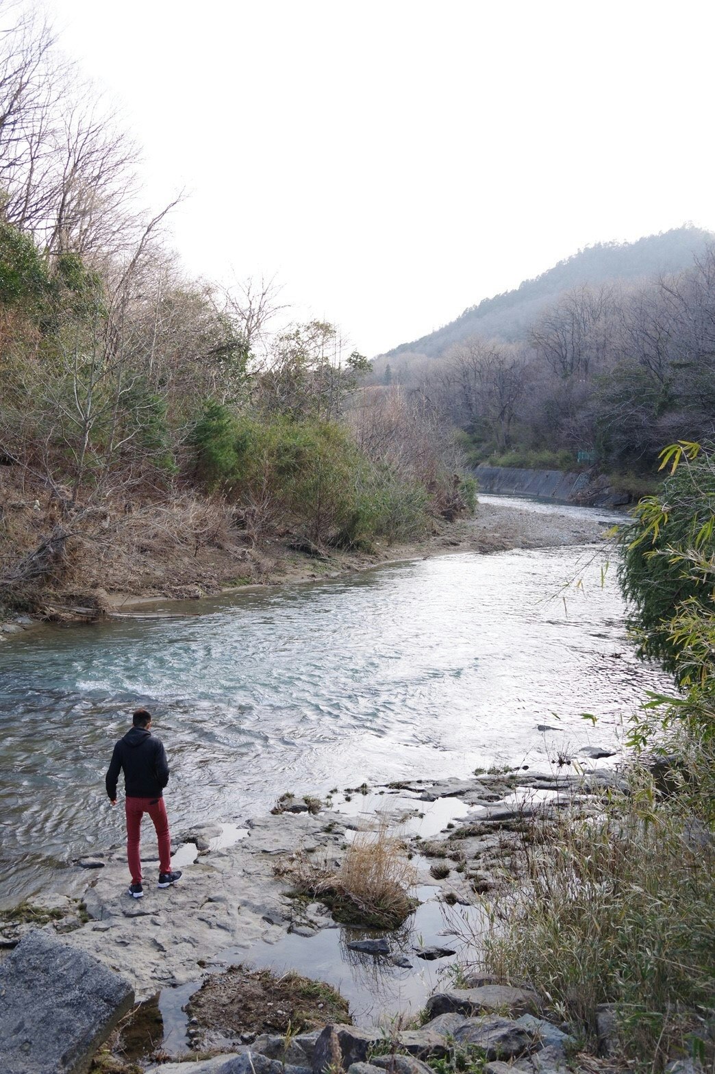 川沿いの渓流で歩く人と山の斜面