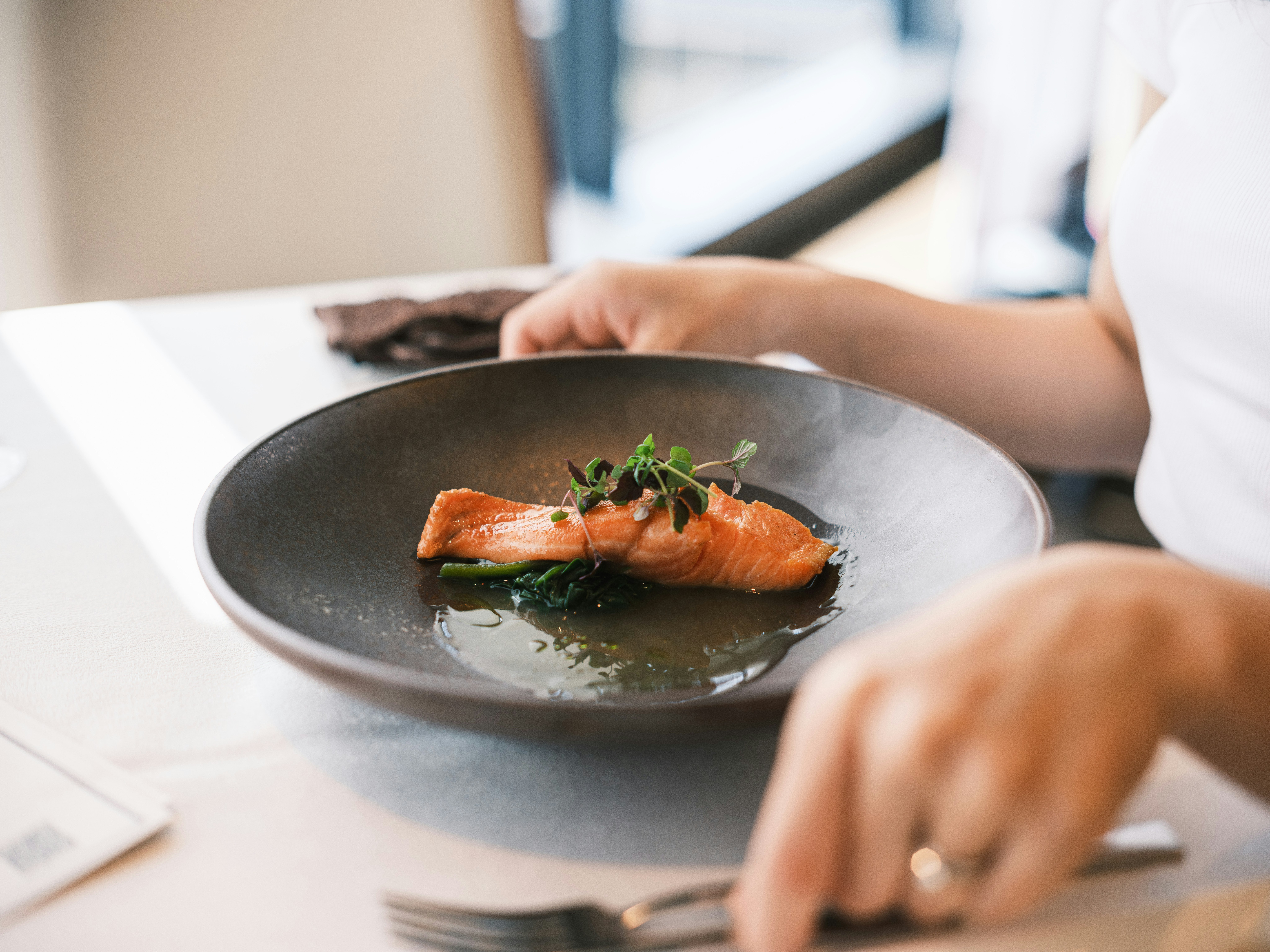 Lachs angerichtet in einer schwarzen Schüssel am Tisch