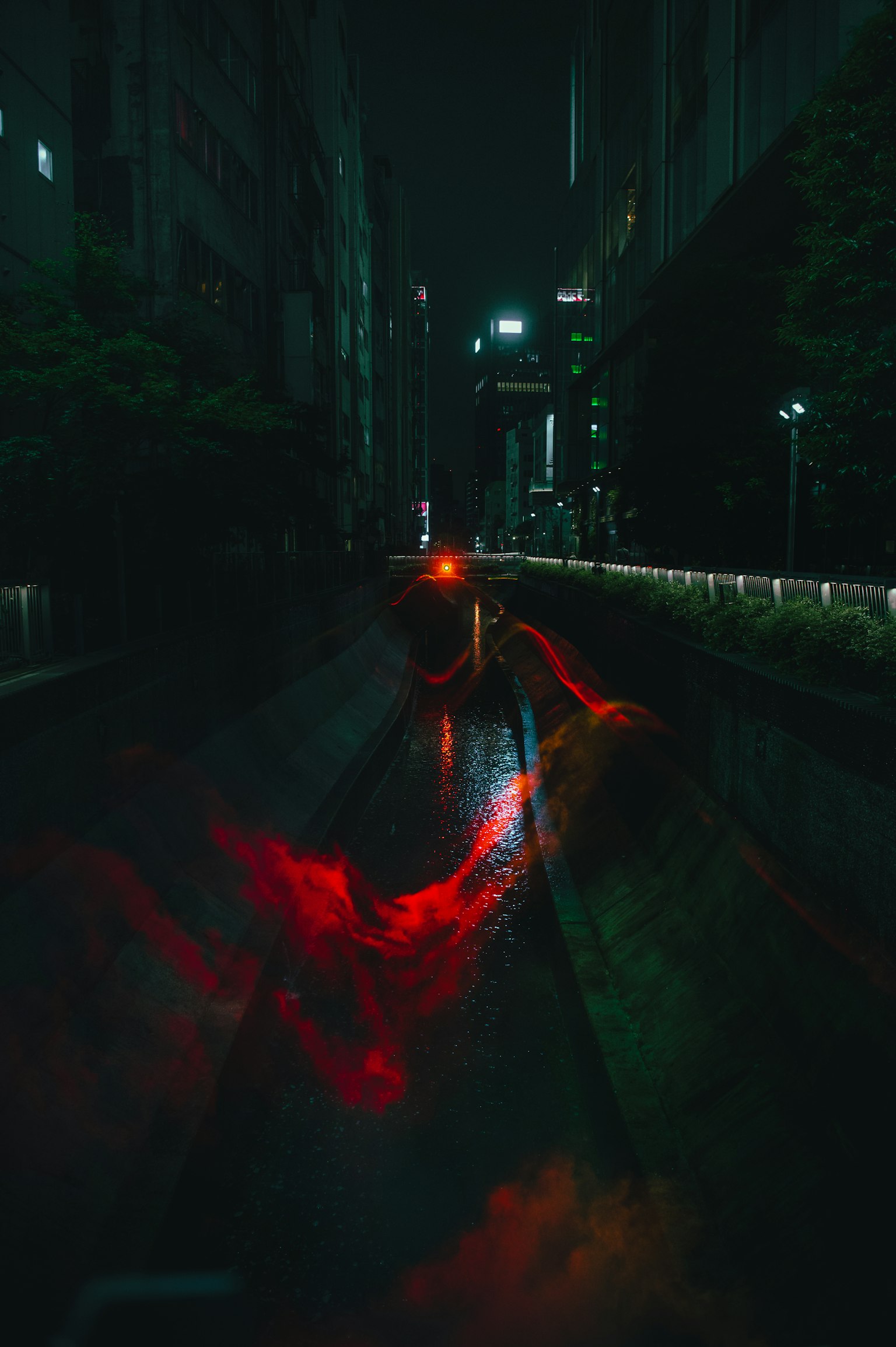 Riflessi di luci rosse e verdi su una strada buia della città