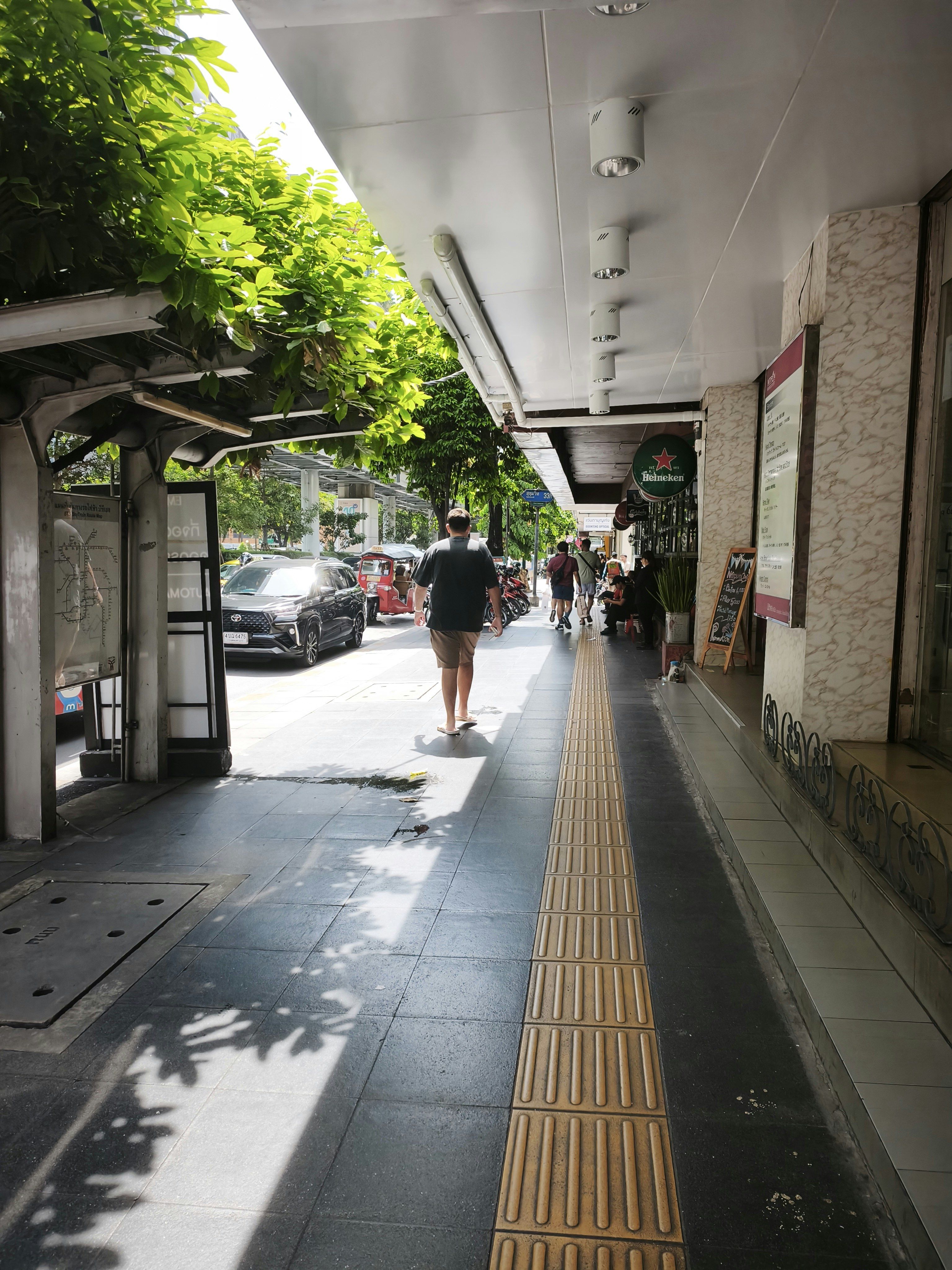 屋根付きの歩道と車道に面した街路の風景