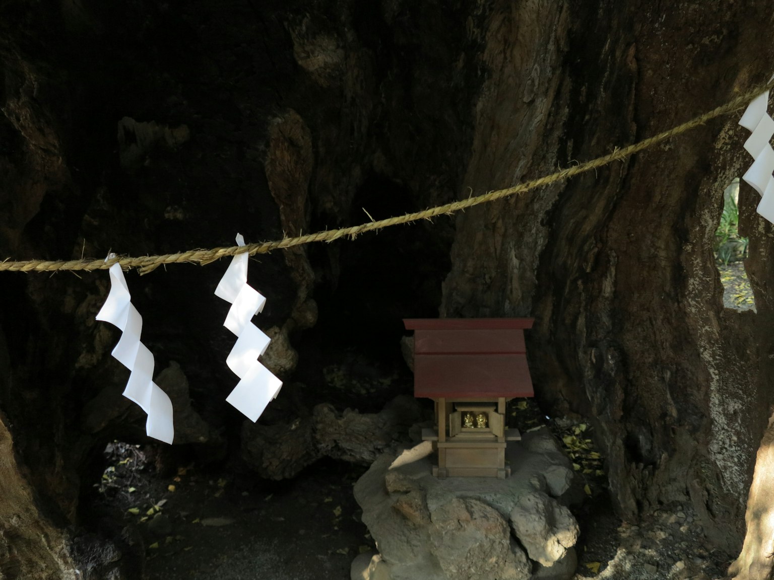 Intérieur de la grotte sacrée avec un petit sanctuaire et shimenawa