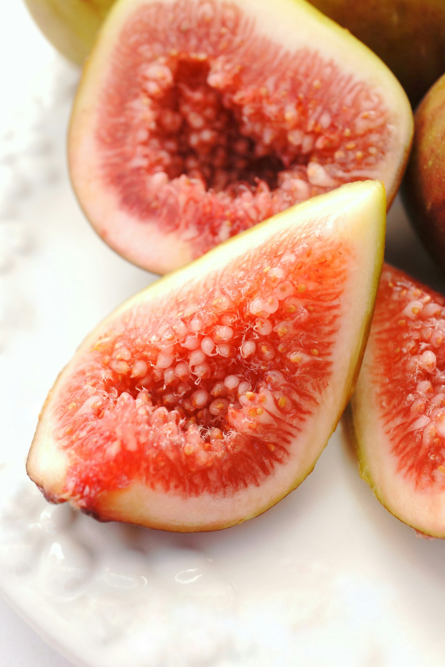Close-up of sliced fig showing pink flesh and white seeds