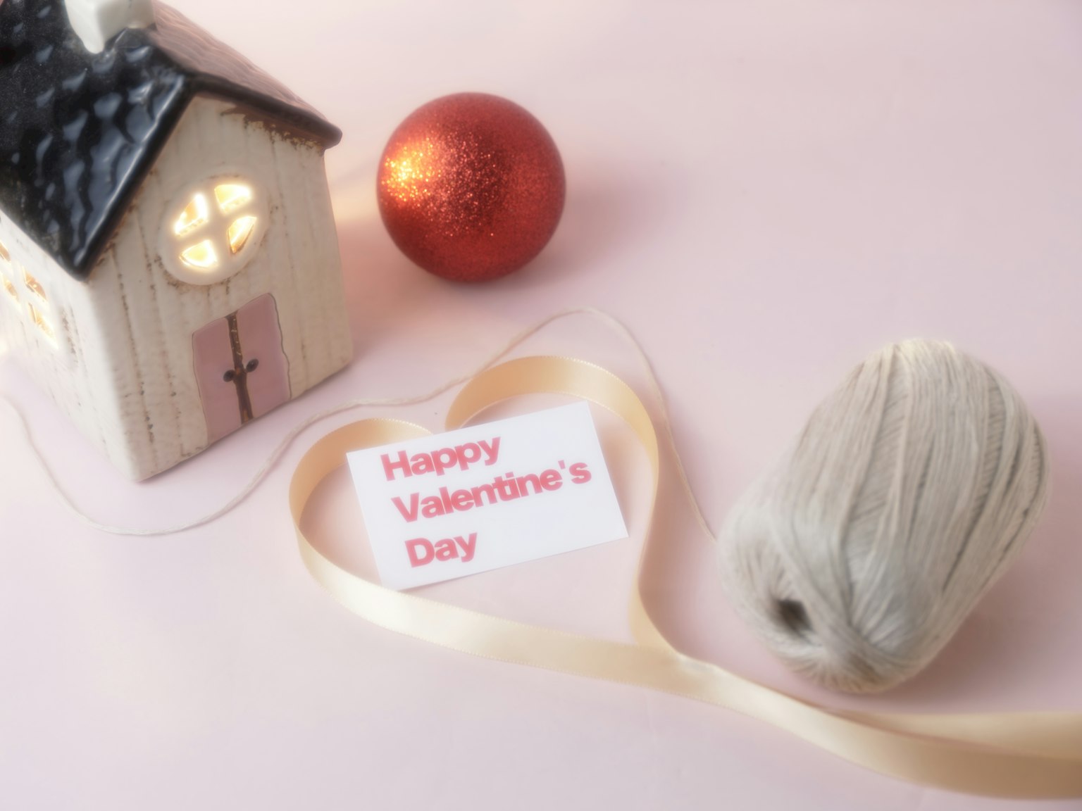 A charming small house with a Valentine's Day message and a red ornament