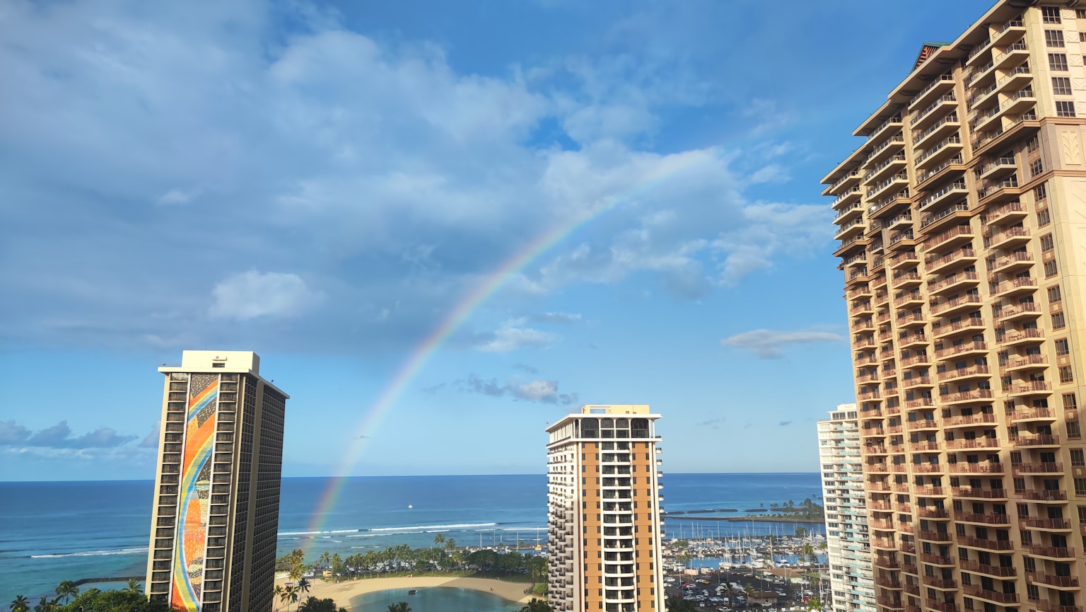A beautiful seascape with a rainbow between high-rise buildings
