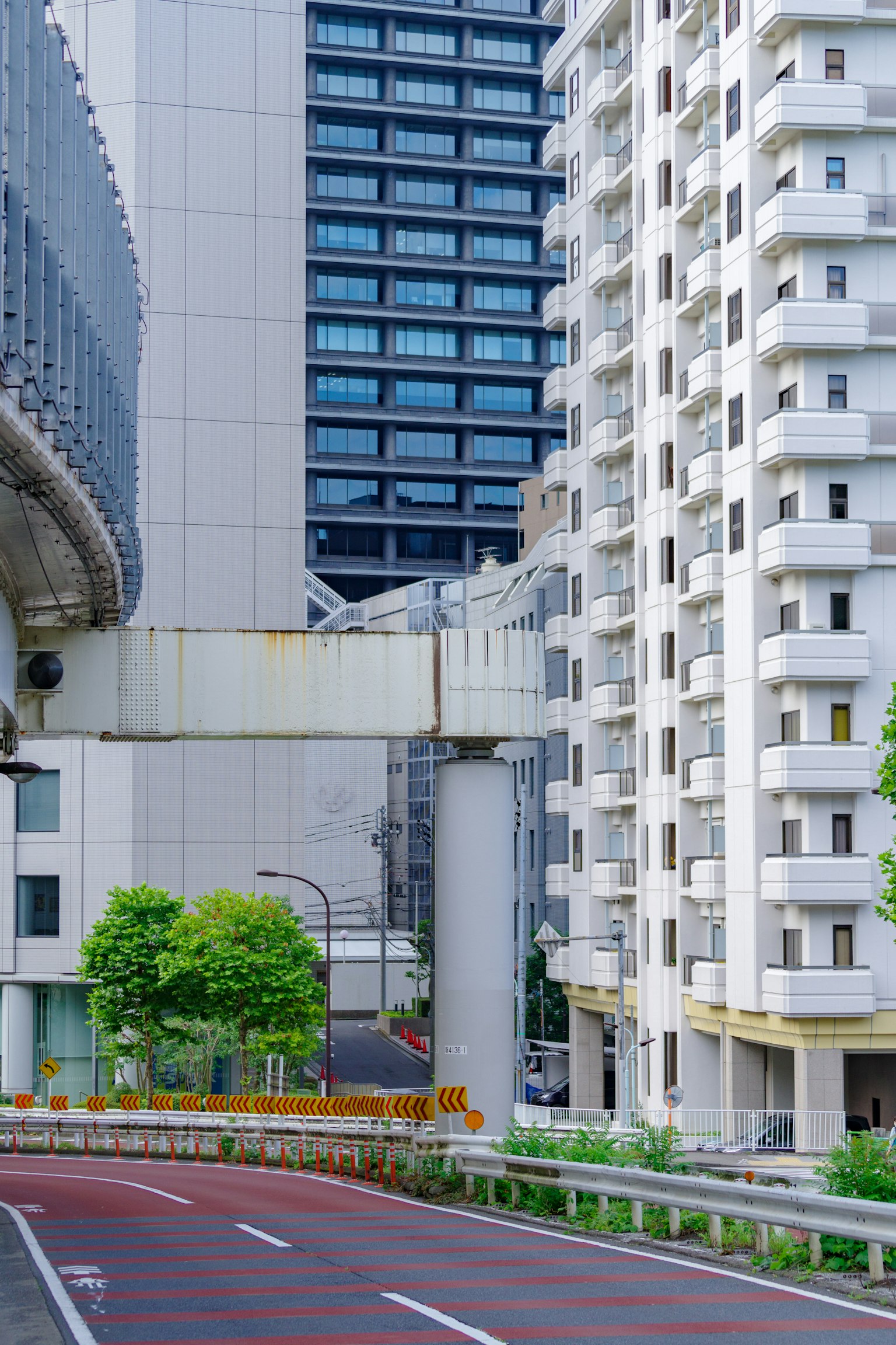 Phong cảnh đô thị với các tòa nhà cao tầng và một con đường cây xanh và cấu trúc bê tông đồng tồn tại