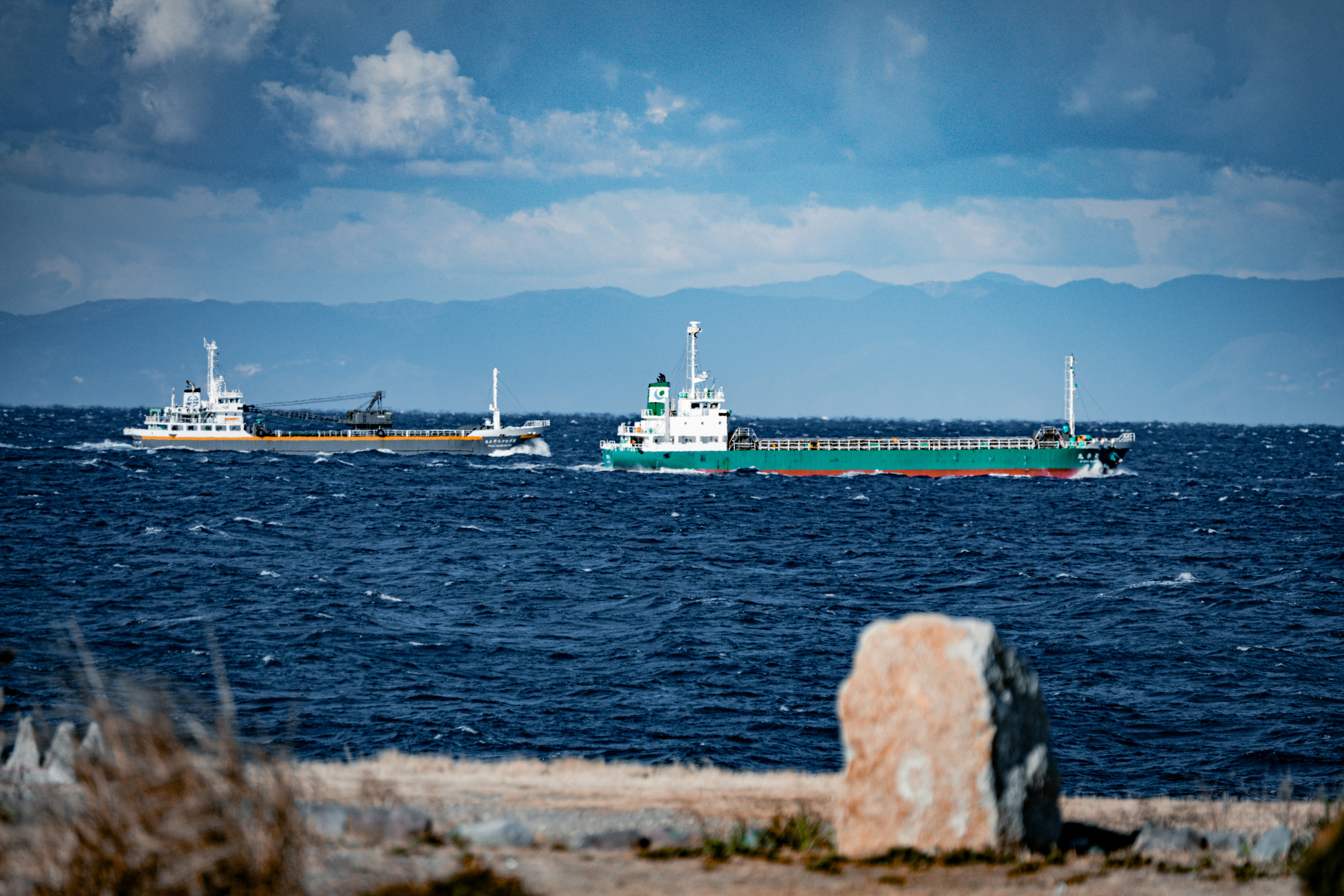海上を航行する貨物船とフェリーのある港の風景