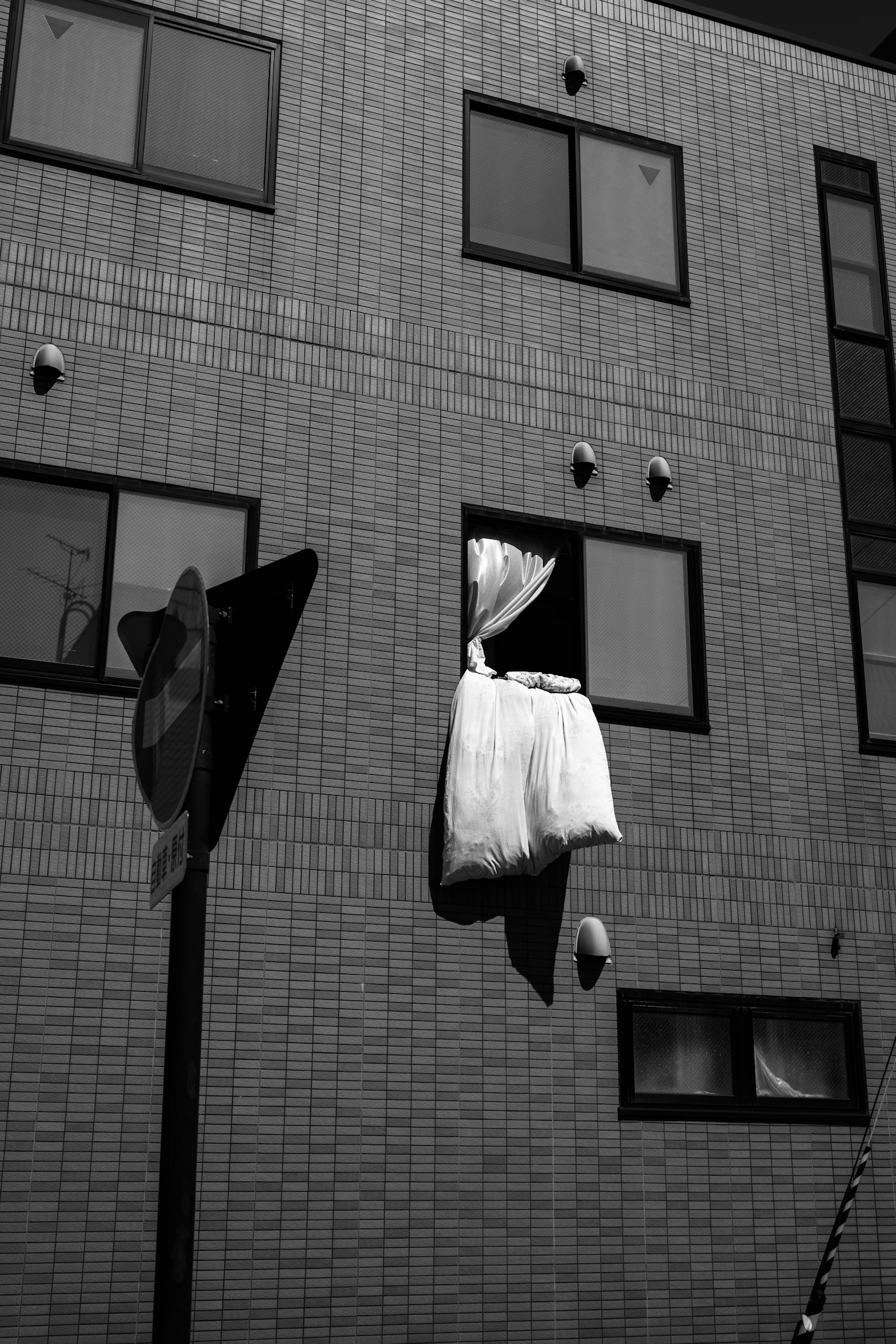 White curtain hanging from a window and surrounding building