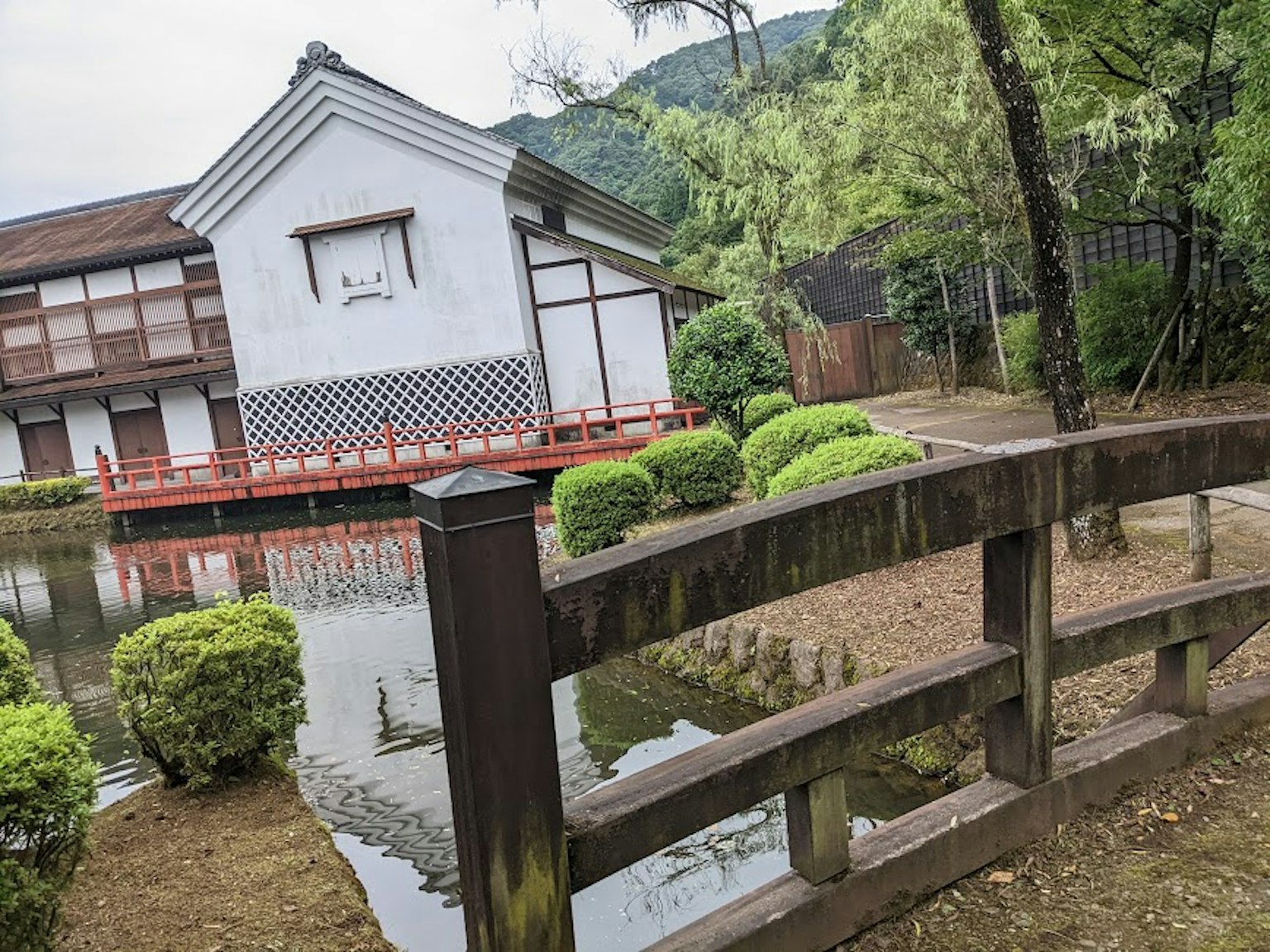 池塘旁的传统日本建筑，绿灌木和木桥