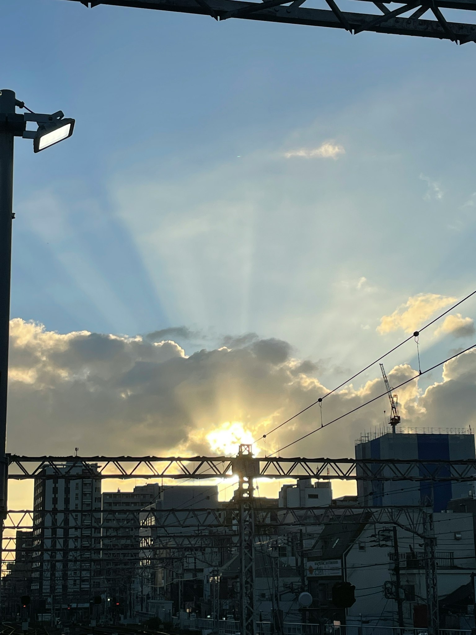Sunset rays shining through clouds in an urban landscape