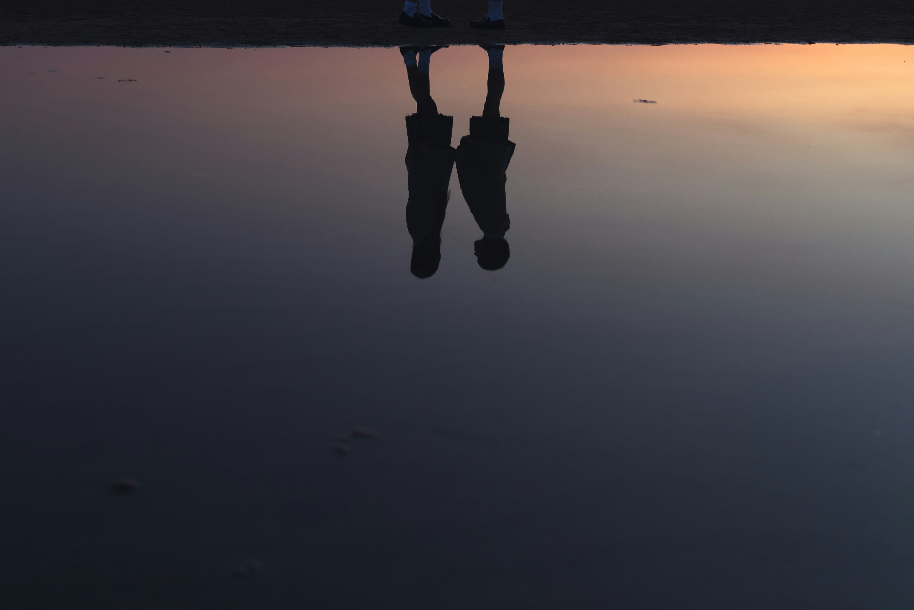 夕暮れの空を背景に宙に浮く人の足元