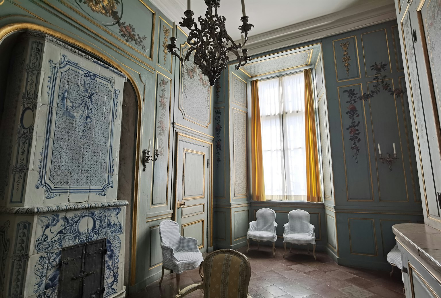 Intérieur d'une pièce avec un lustre orné et des murs teal
