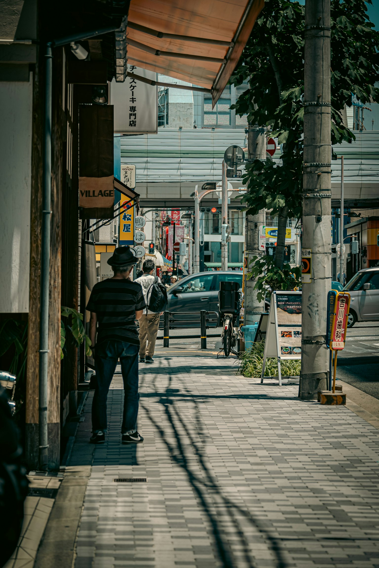 一个人走在安静的街道上，旁边有商店