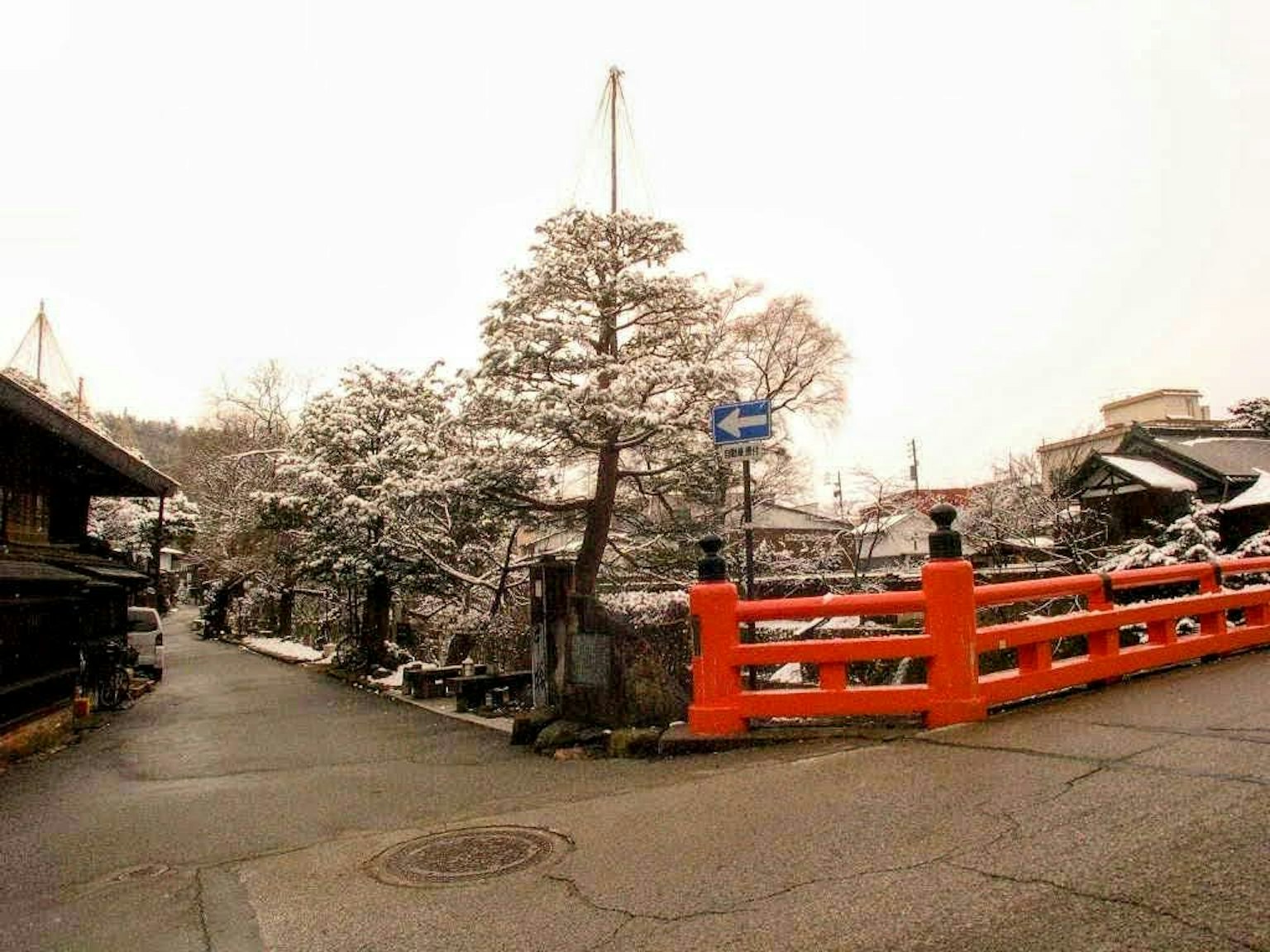 Ponte rosso coperto di neve con paesaggio circostante