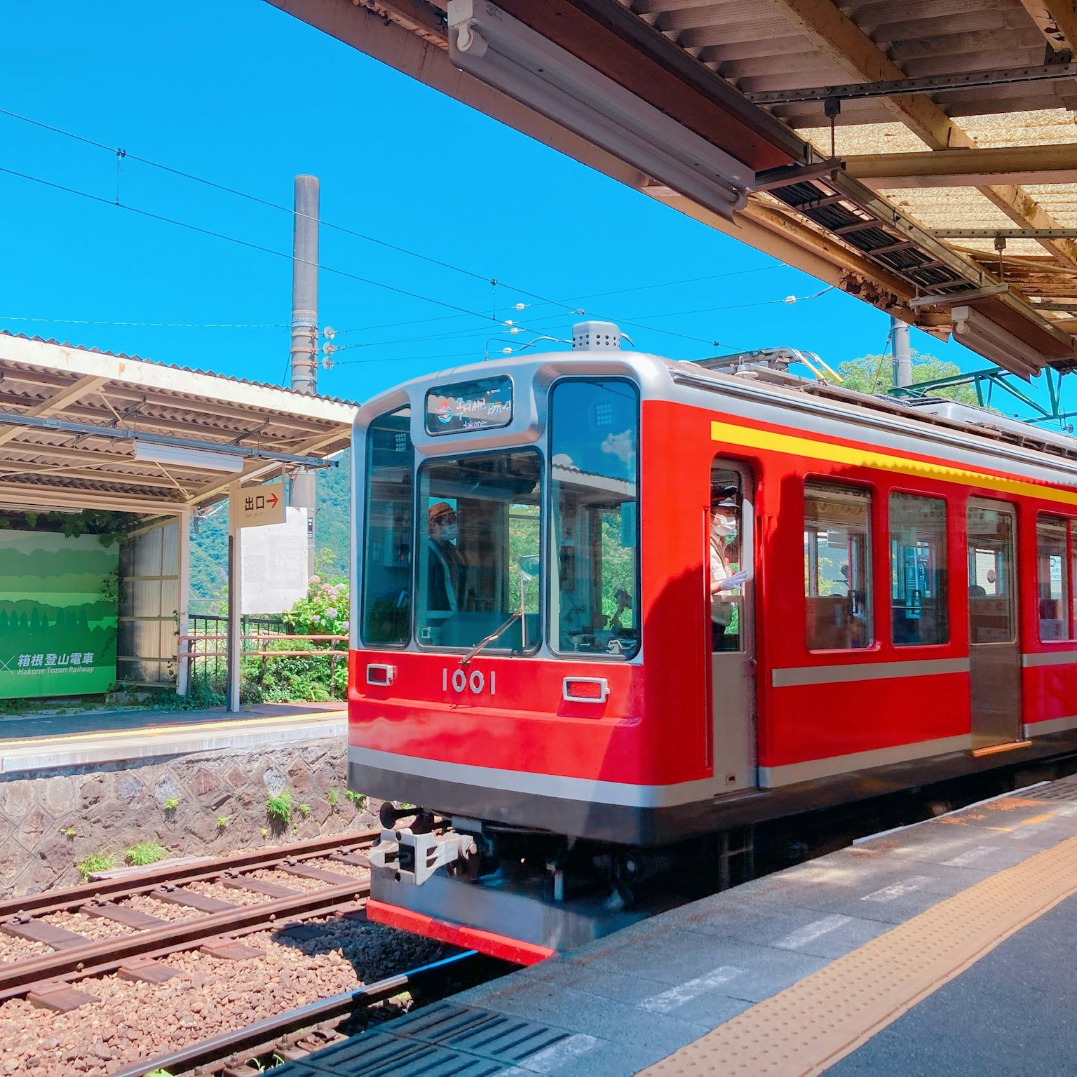 Train rouge à une station sous un ciel bleu clair