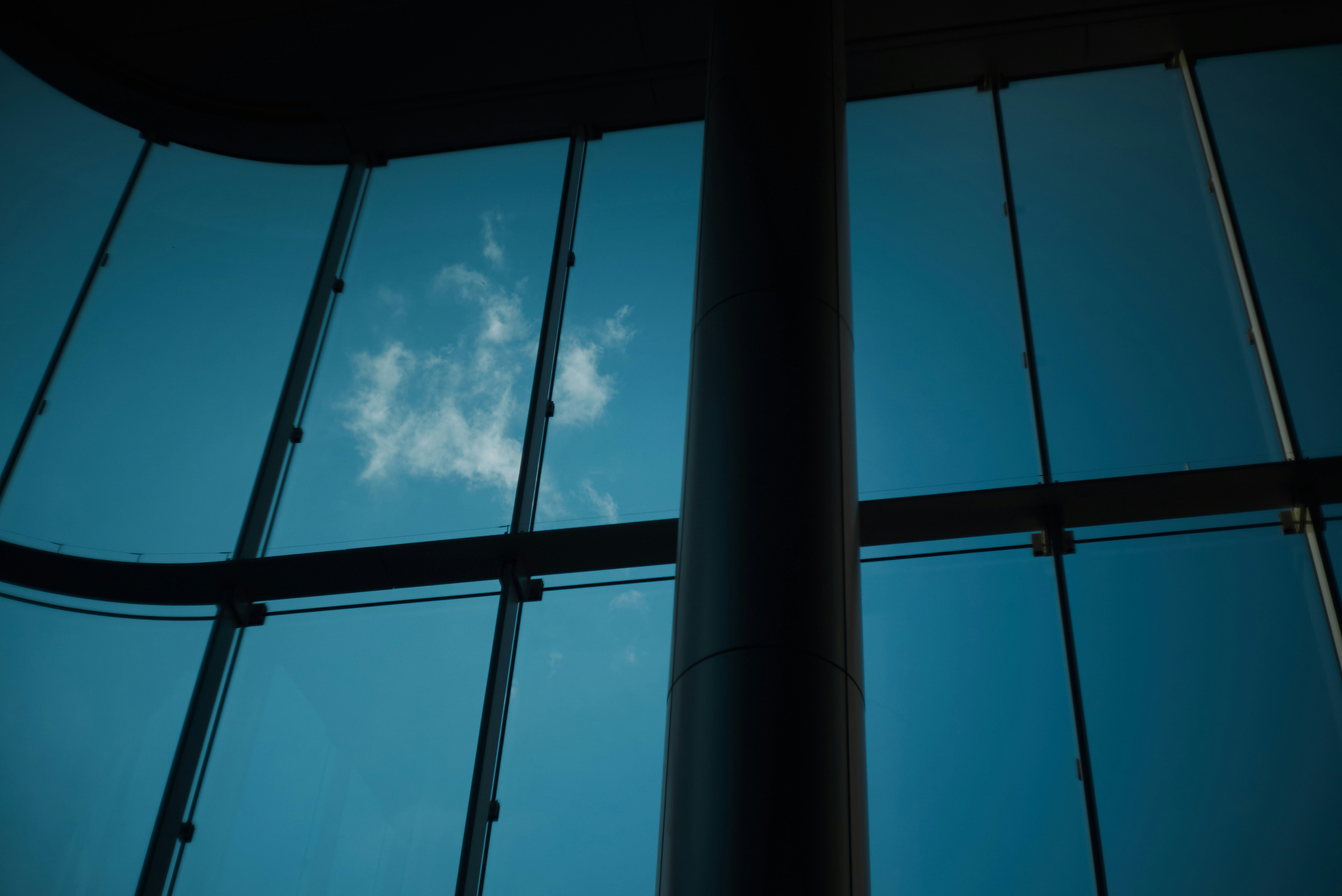 glass building columns and windows reflecting a blue sky