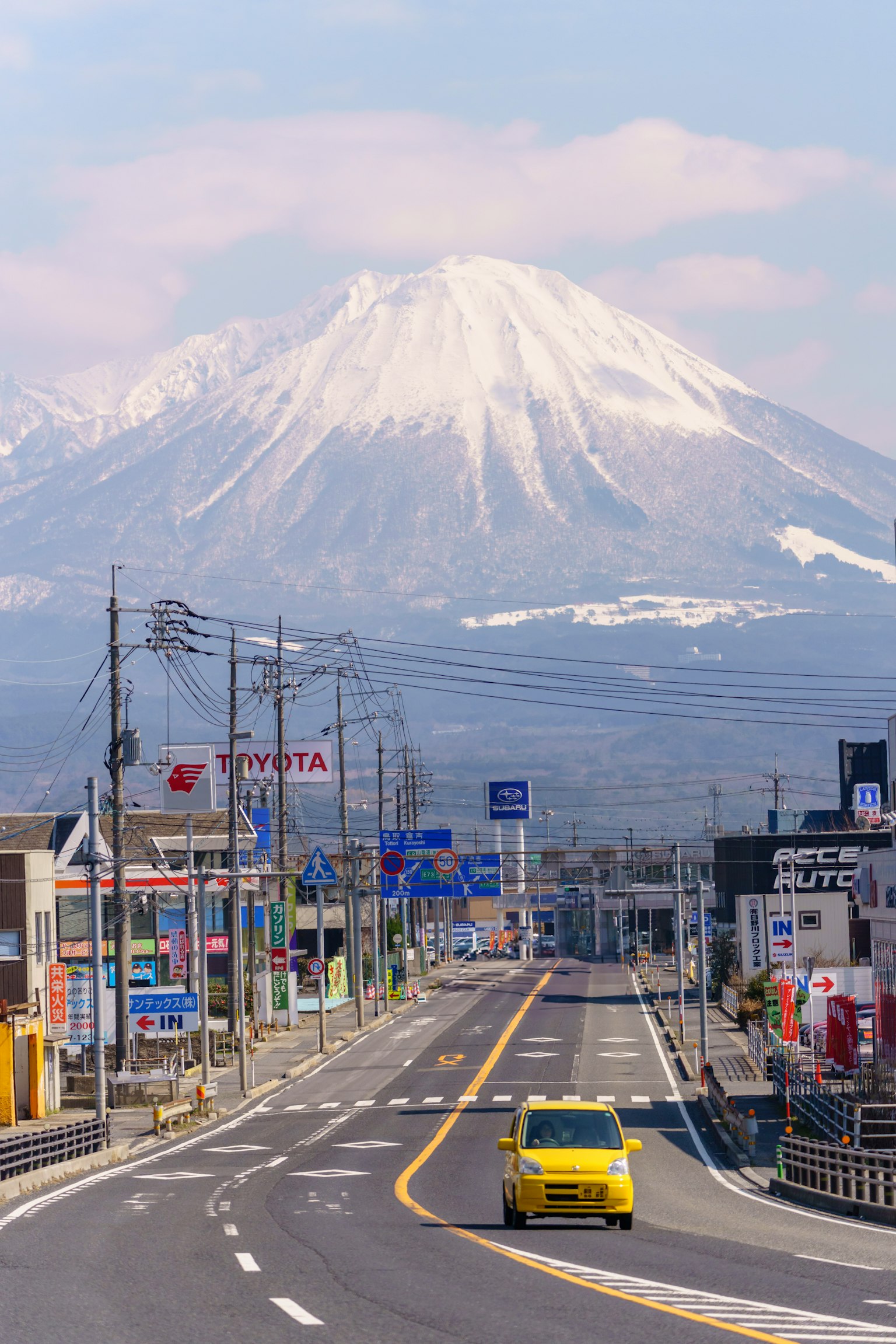 Pemandangan jalan dengan gunung bersalju dan bangunan kota