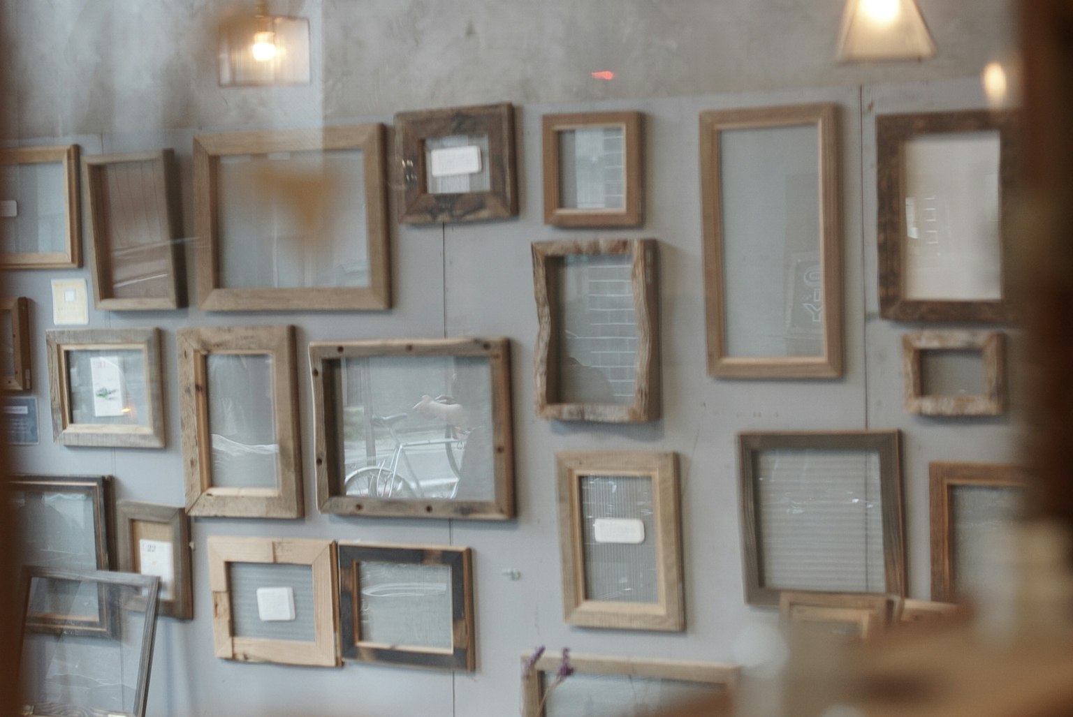 Interno di una galleria d'arte con cornici in legno appese al muro