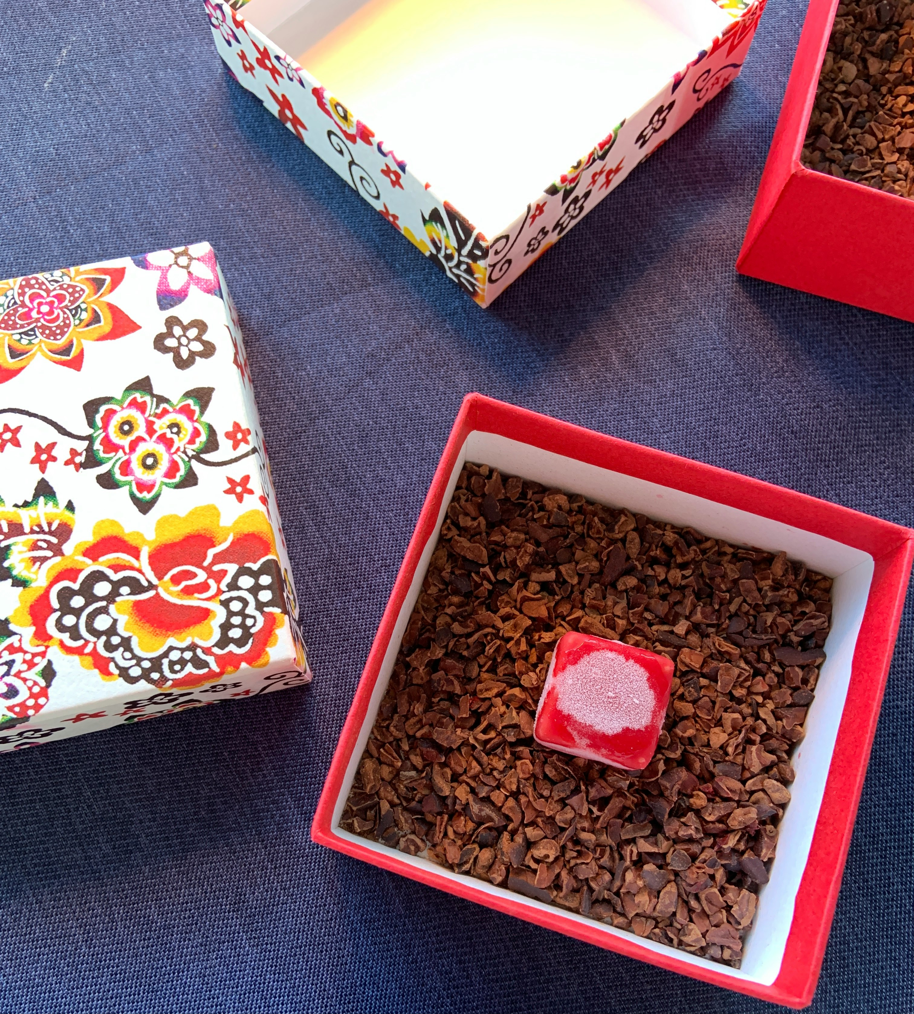 bàn tiệc với cacao nibs trong hộp đỏ và món tráng miệng