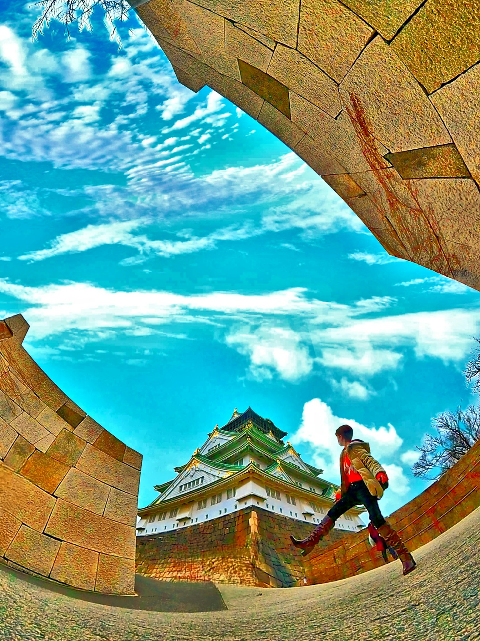 Person, die mit dem Nagoya-Schloss im Hintergrund unter einem blauen Himmel geht