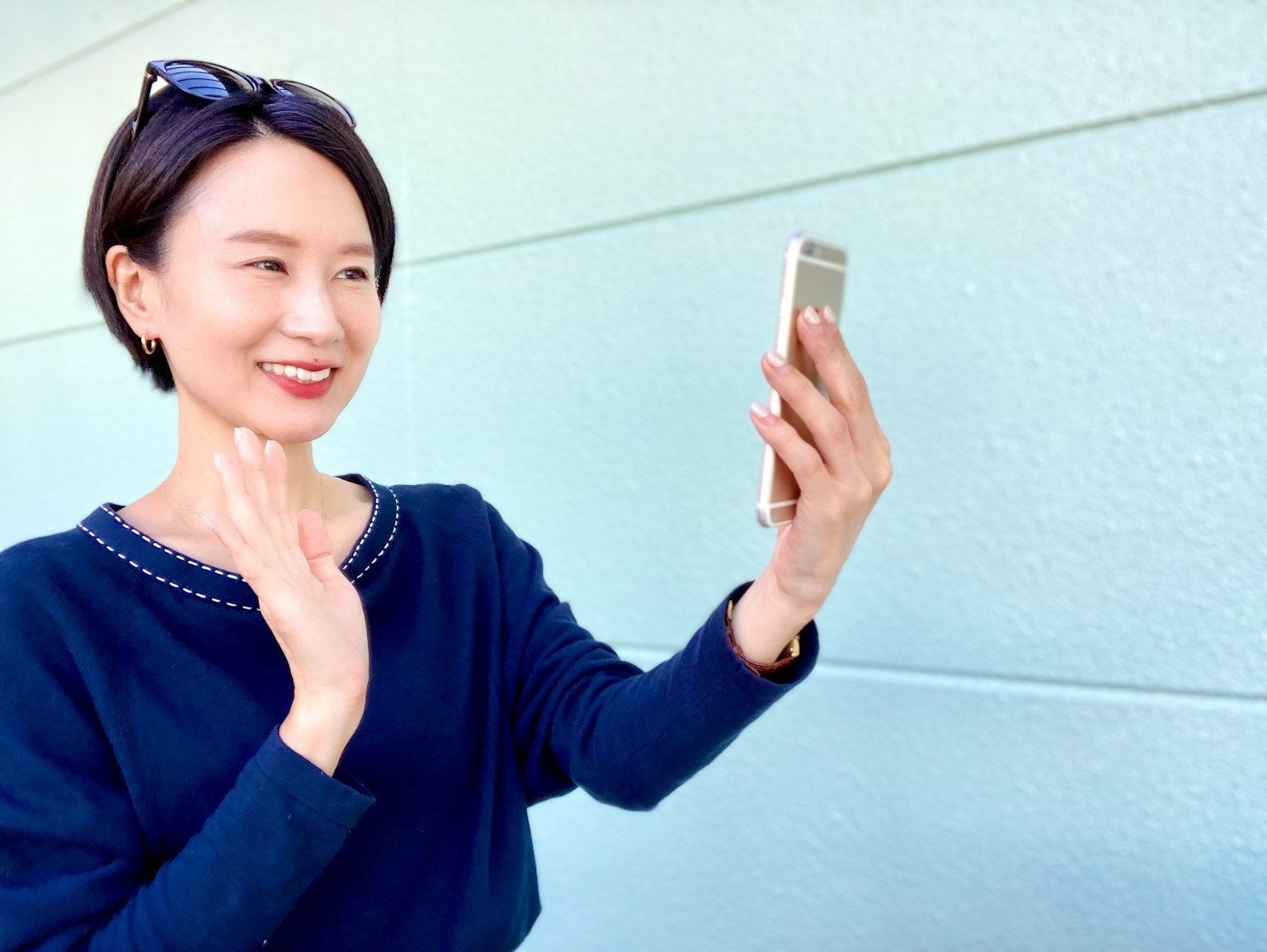 女性用智能手机自拍微笑并挥手