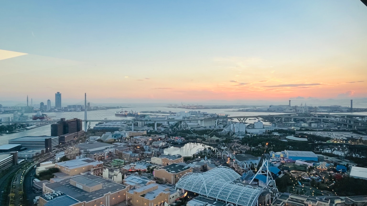 Panoramic city view from a high-rise building with a sunset sky and river