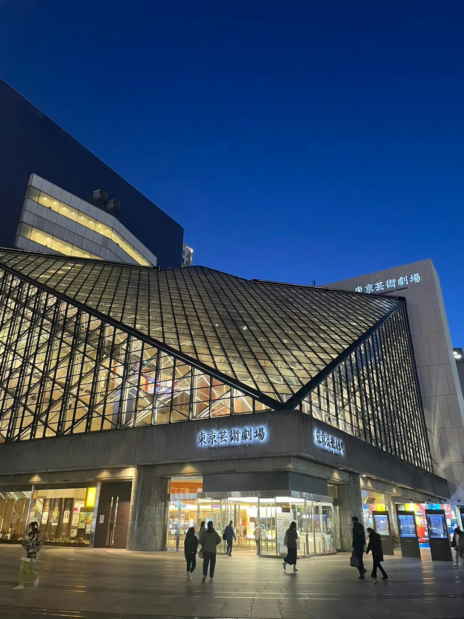 Esterno moderno di un edificio sotto il cielo notturno con tetto in vetro e design angolare