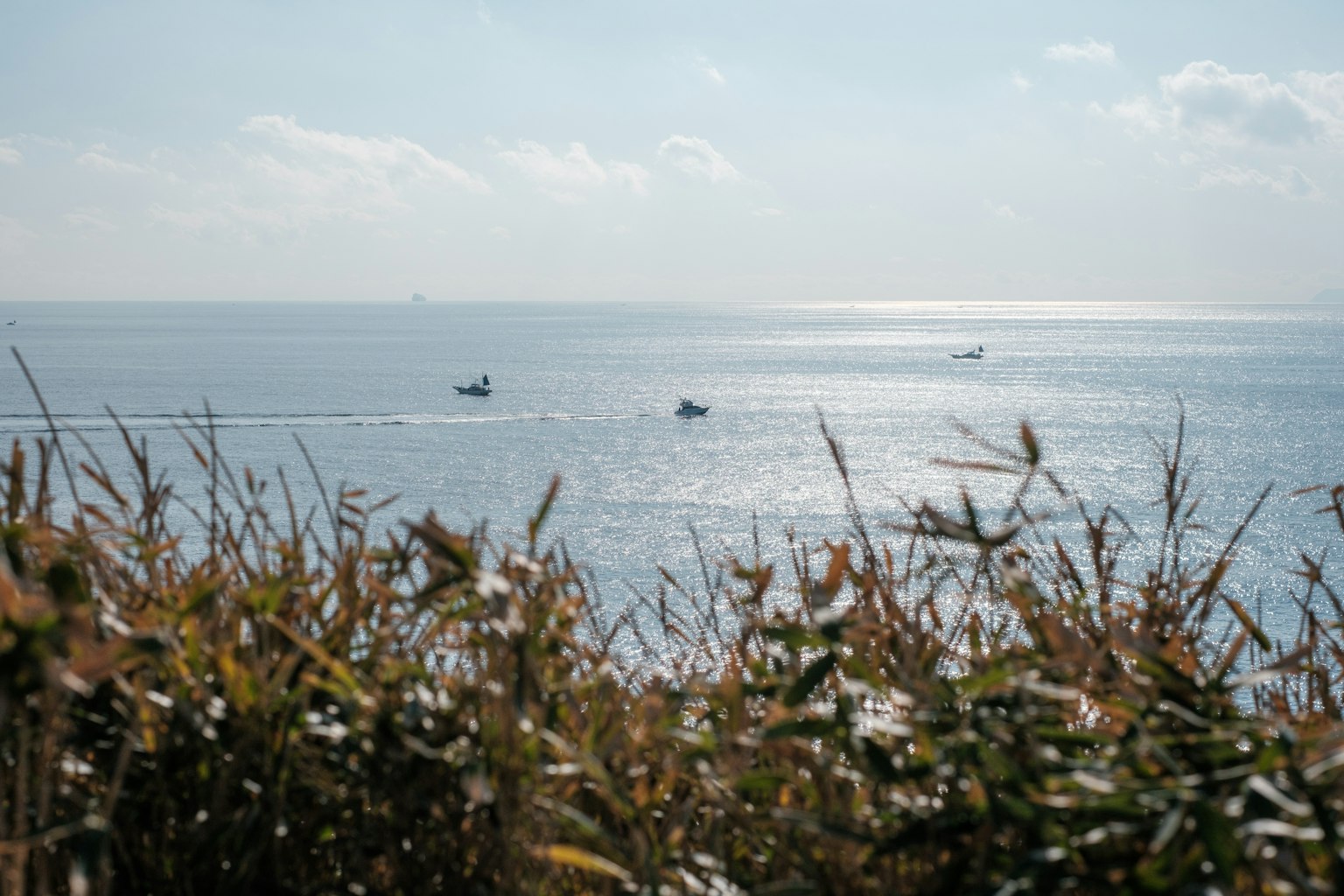 View of small boats on the ocean with a calm surface